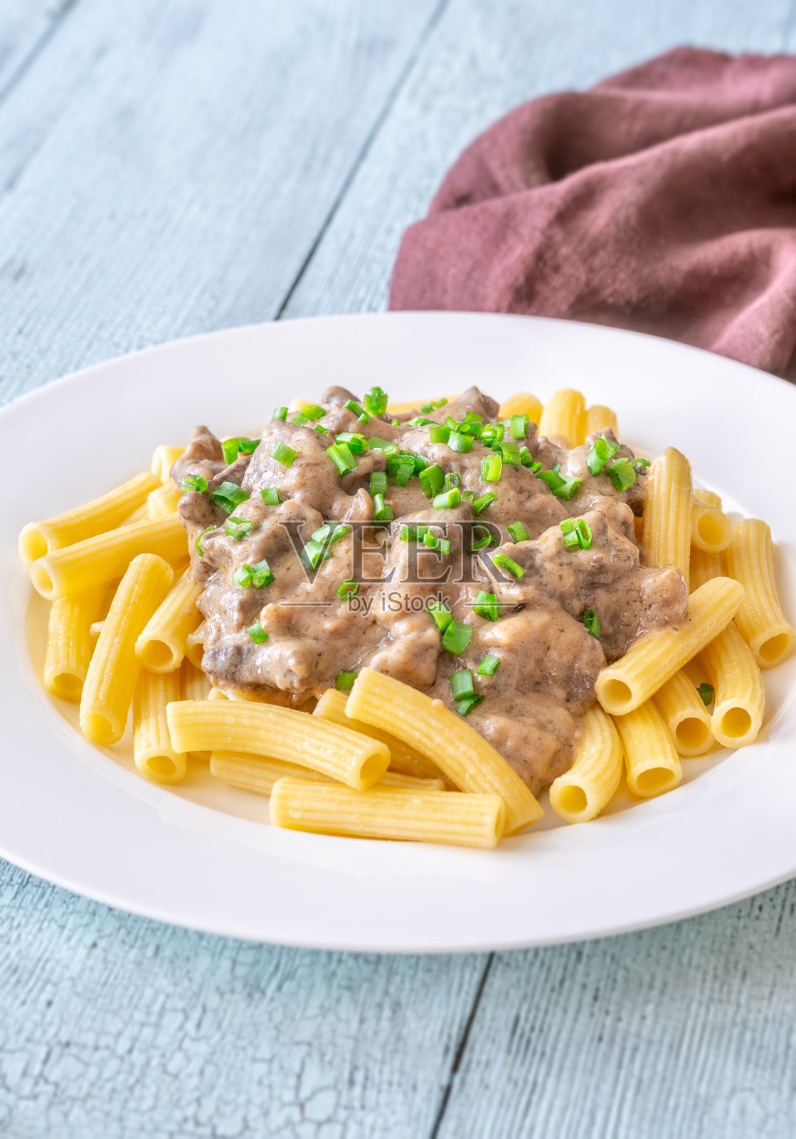 牛肉斯特罗根诺夫配通心粉,上面撒有新鲜的青葱装饰照片摄影图片