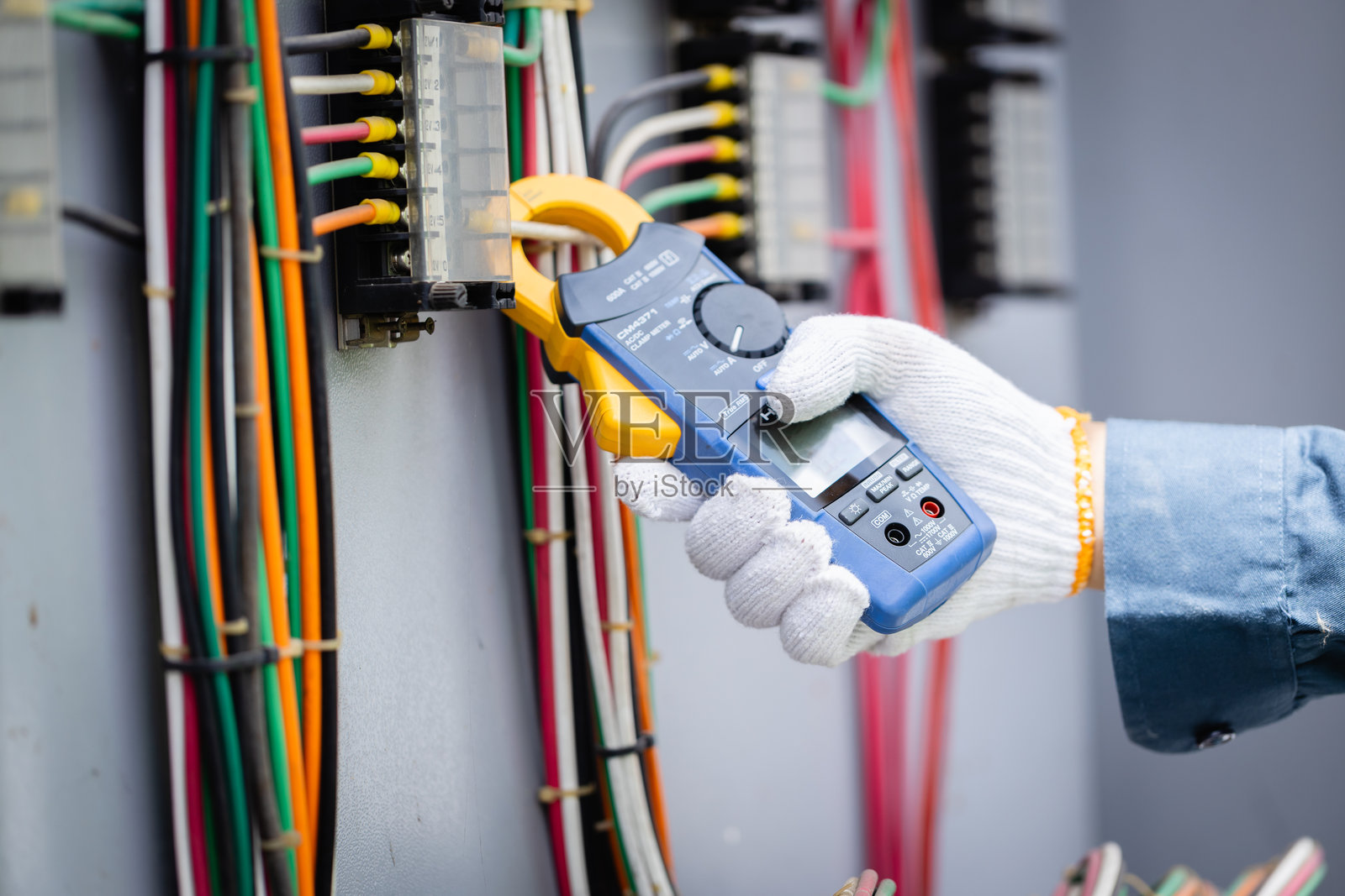 工程师正在高压电力变电站进行检查,使用专业工具对电气基础设施进行安全和准确的检查。照片摄影图片