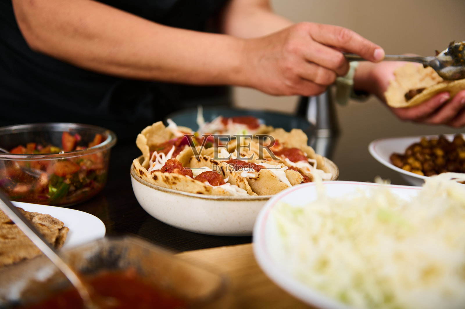 在厨房环境中用新鲜食材准备自制塔可的双手照片摄影图片