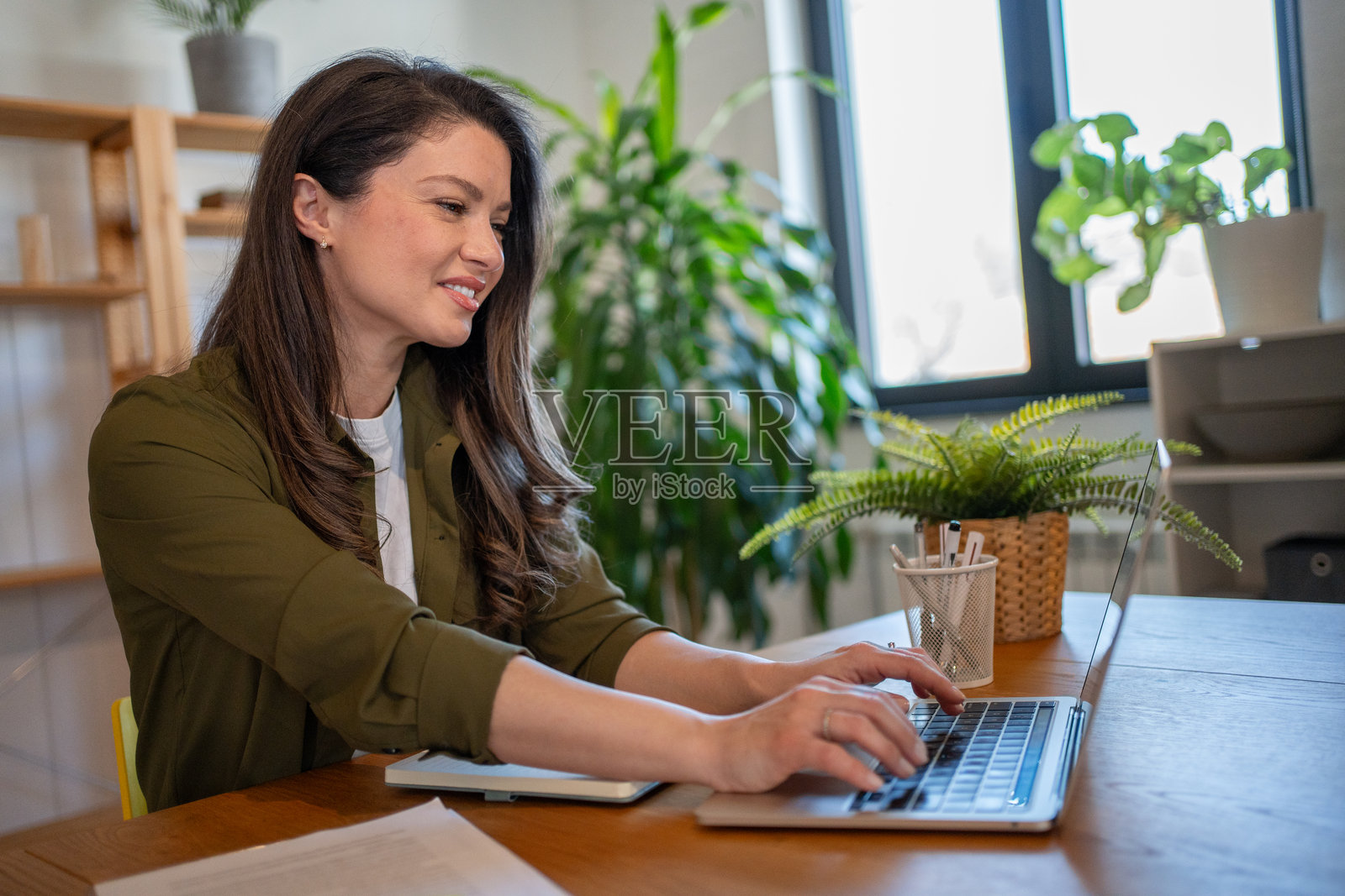 年轻女商人在家中使用笔记本电脑工作照片摄影图片