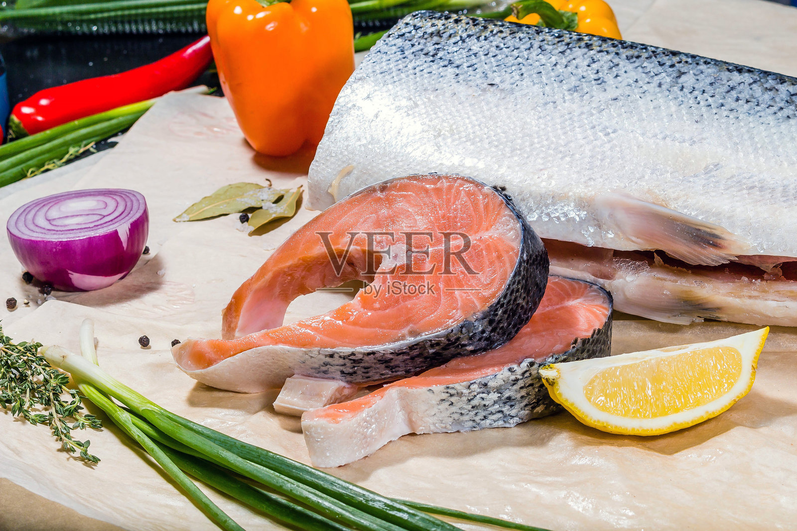 三文鱼是一大块,切成与蔬菜和水果搭配的块状。柠檬胡椒洋葱照片摄影图片