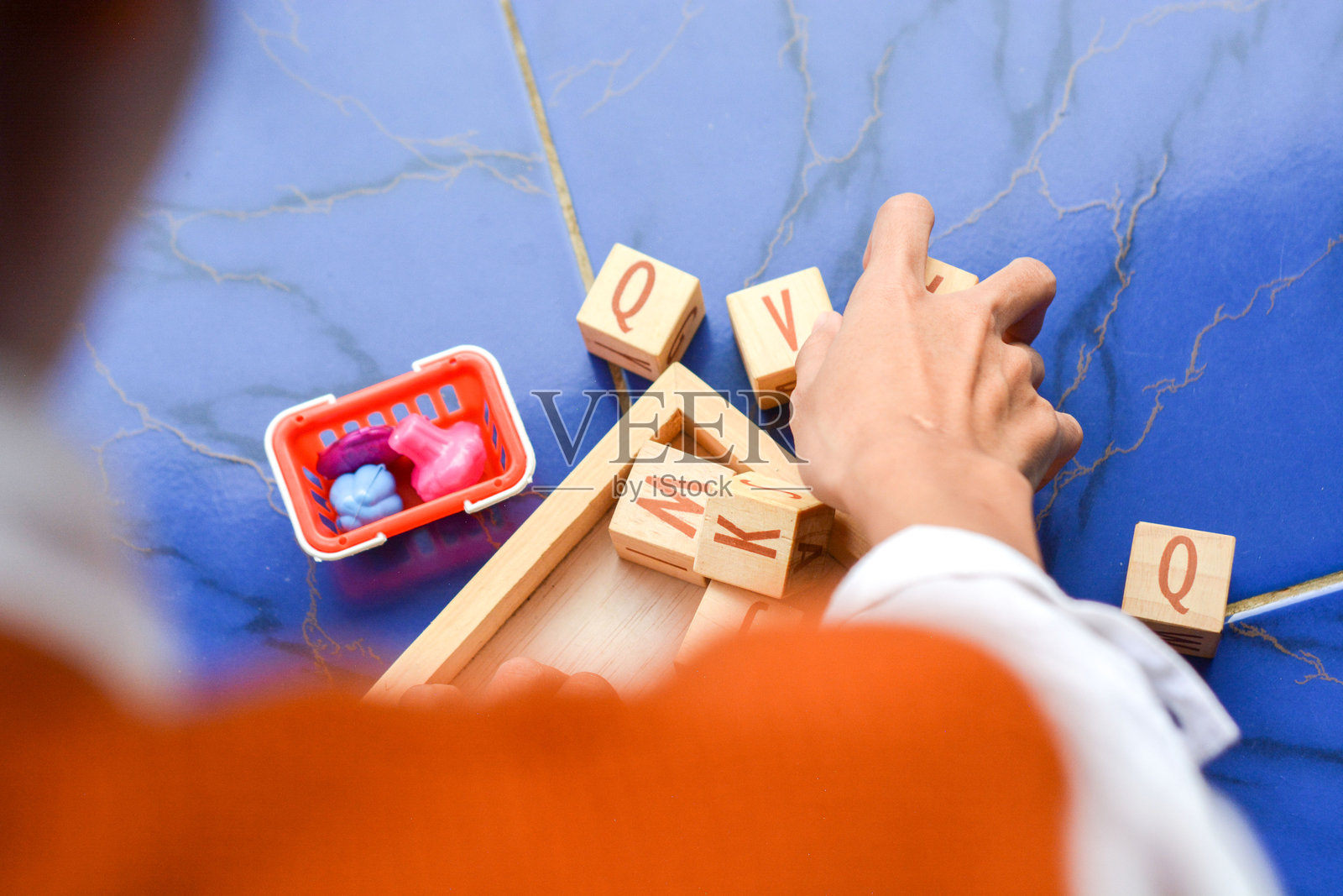 小孩子们坐在地板上一起玩木制积木,享受家庭团聚的时光。照片摄影图片