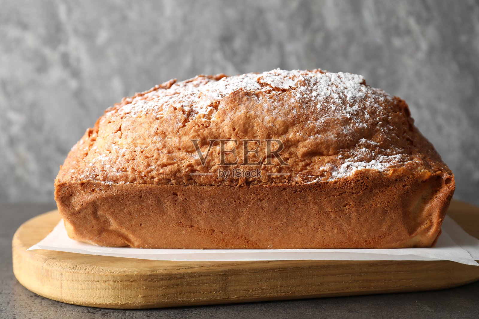美味的海绵蛋糕上撒有糖粉,放在灰色桌子上,特写镜头照片摄影图片