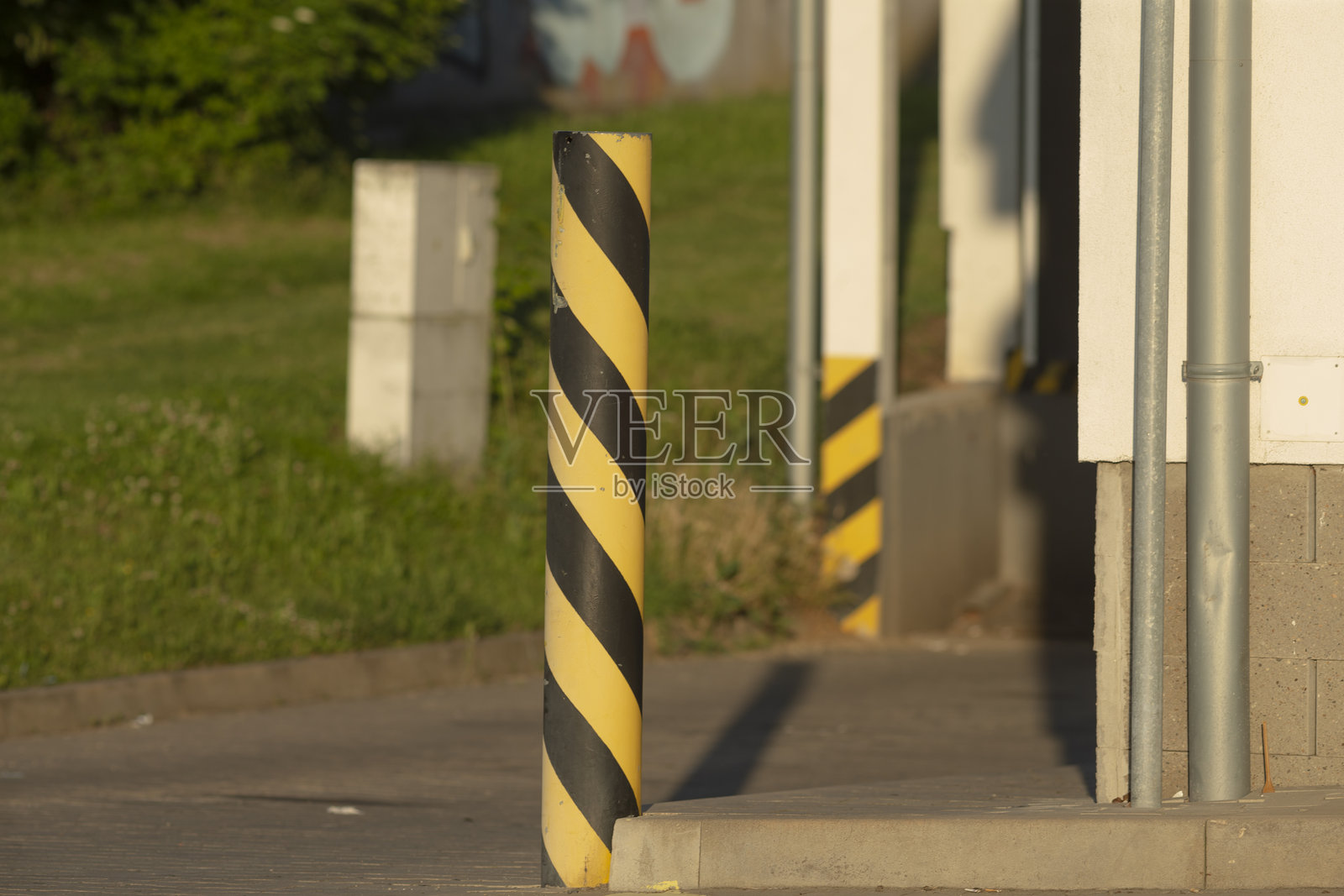 一根黄色和黑色条纹的杆子矗立在建筑物前面照片摄影图片