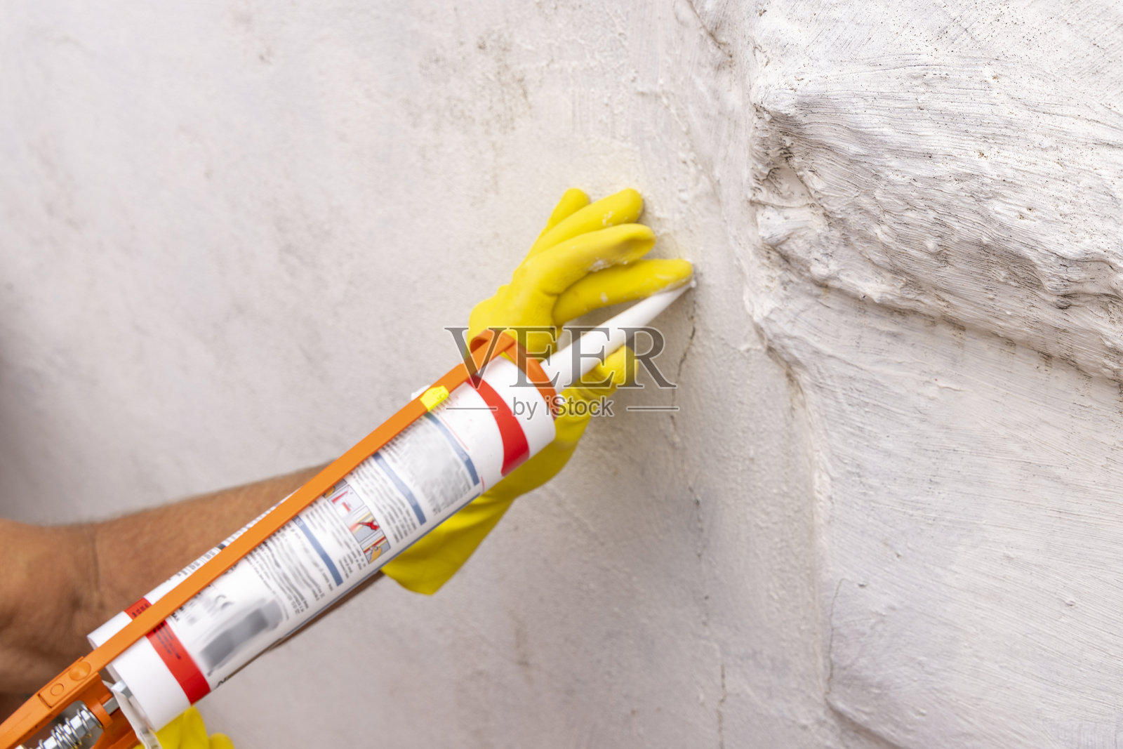 男子在户外墙壁上填补裂缝照片摄影图片