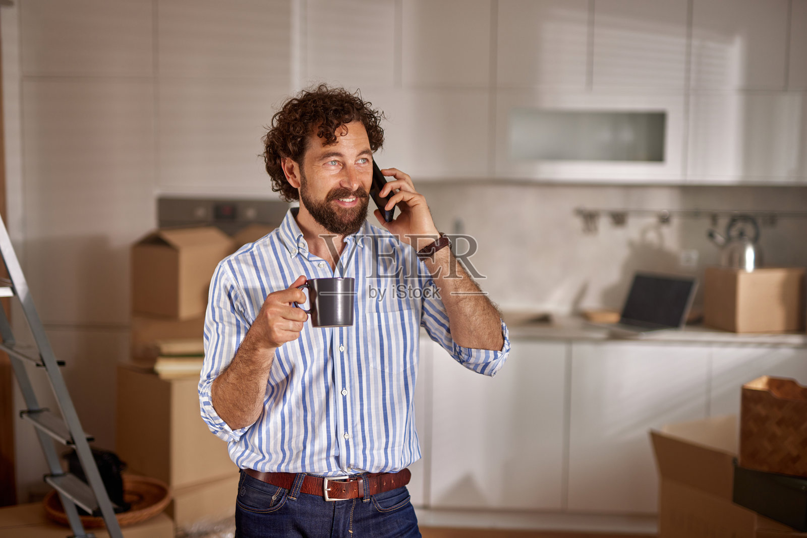 男人在新家里喝咖啡并打电话照片摄影图片