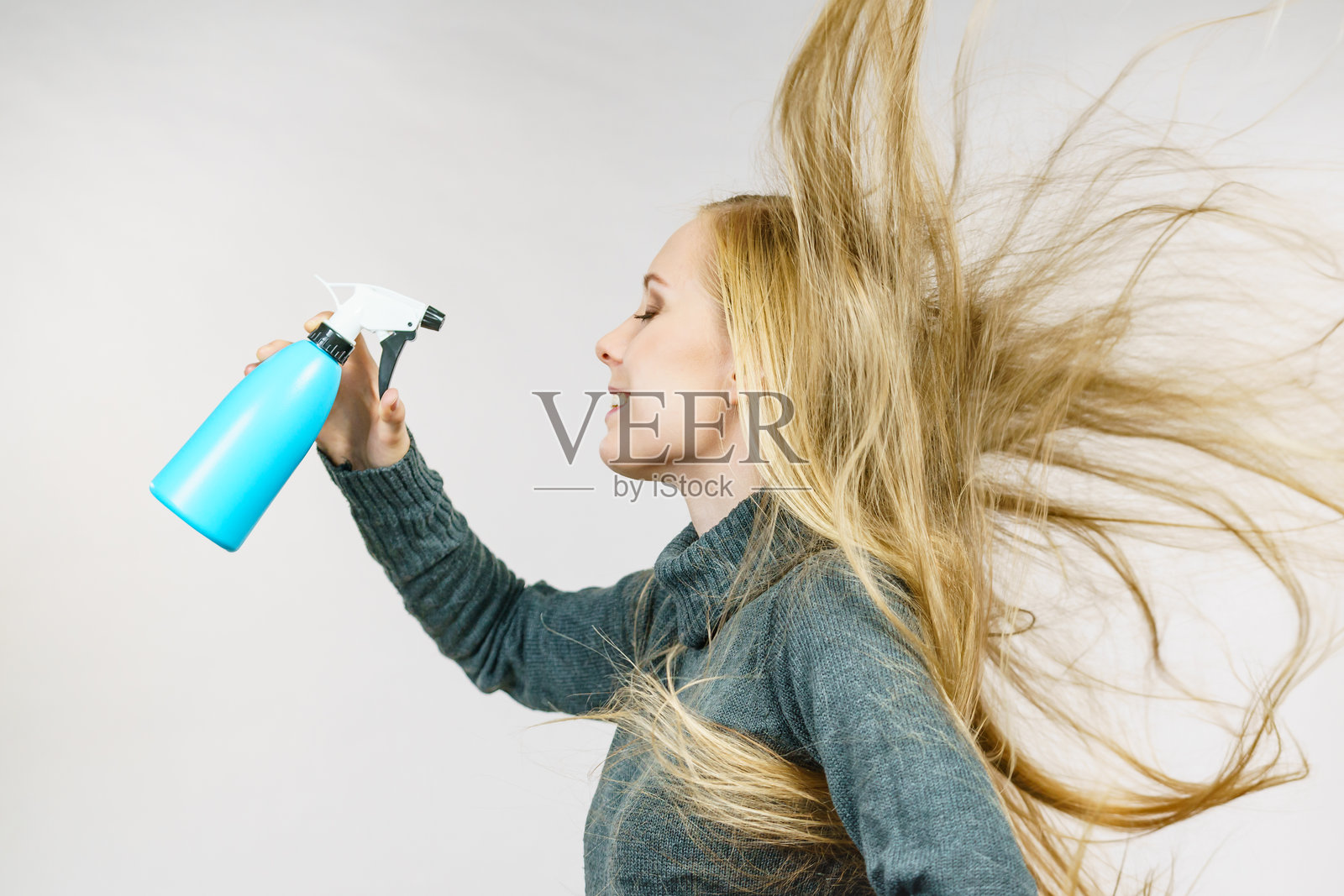 女孩蓬乱的头发拿着喷雾瓶照片摄影图片