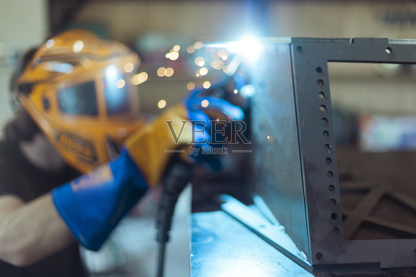 工匠专注于精确焊接铁材,保持稳定的控制,确保良好的质量。照片摄影图片