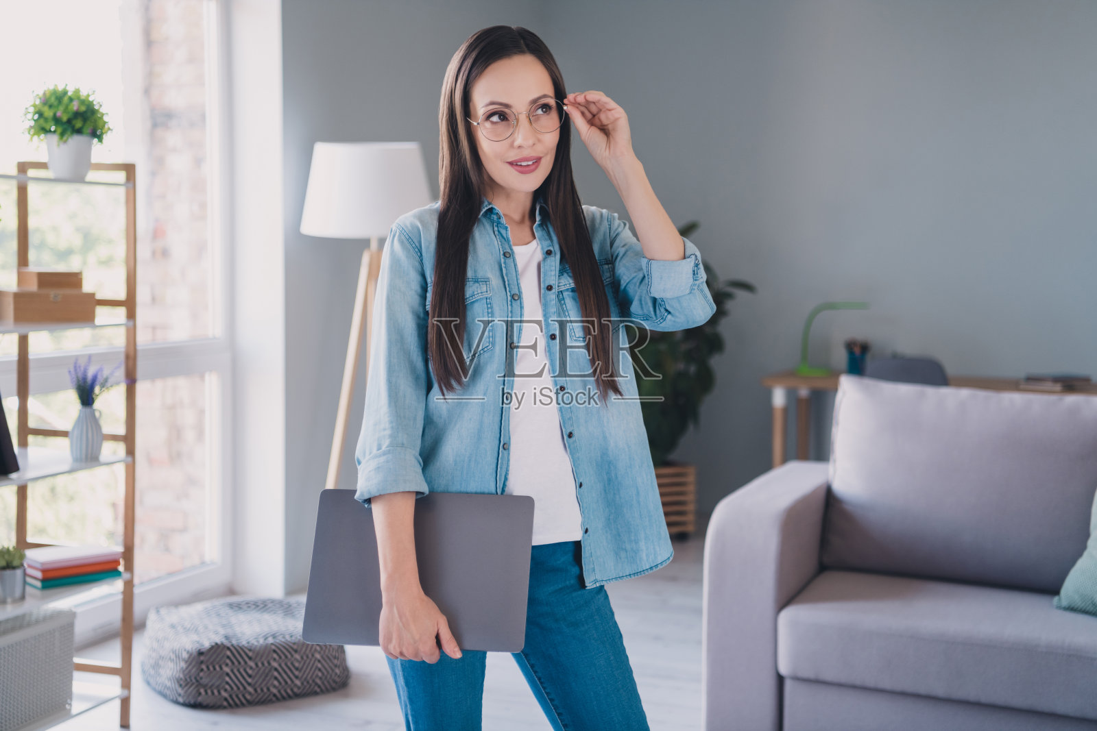 梦幻般快乐积极的成熟的女性,戴着眼镜,想象着在室内家中使用笔记本电脑的自由职业者照片摄影图片