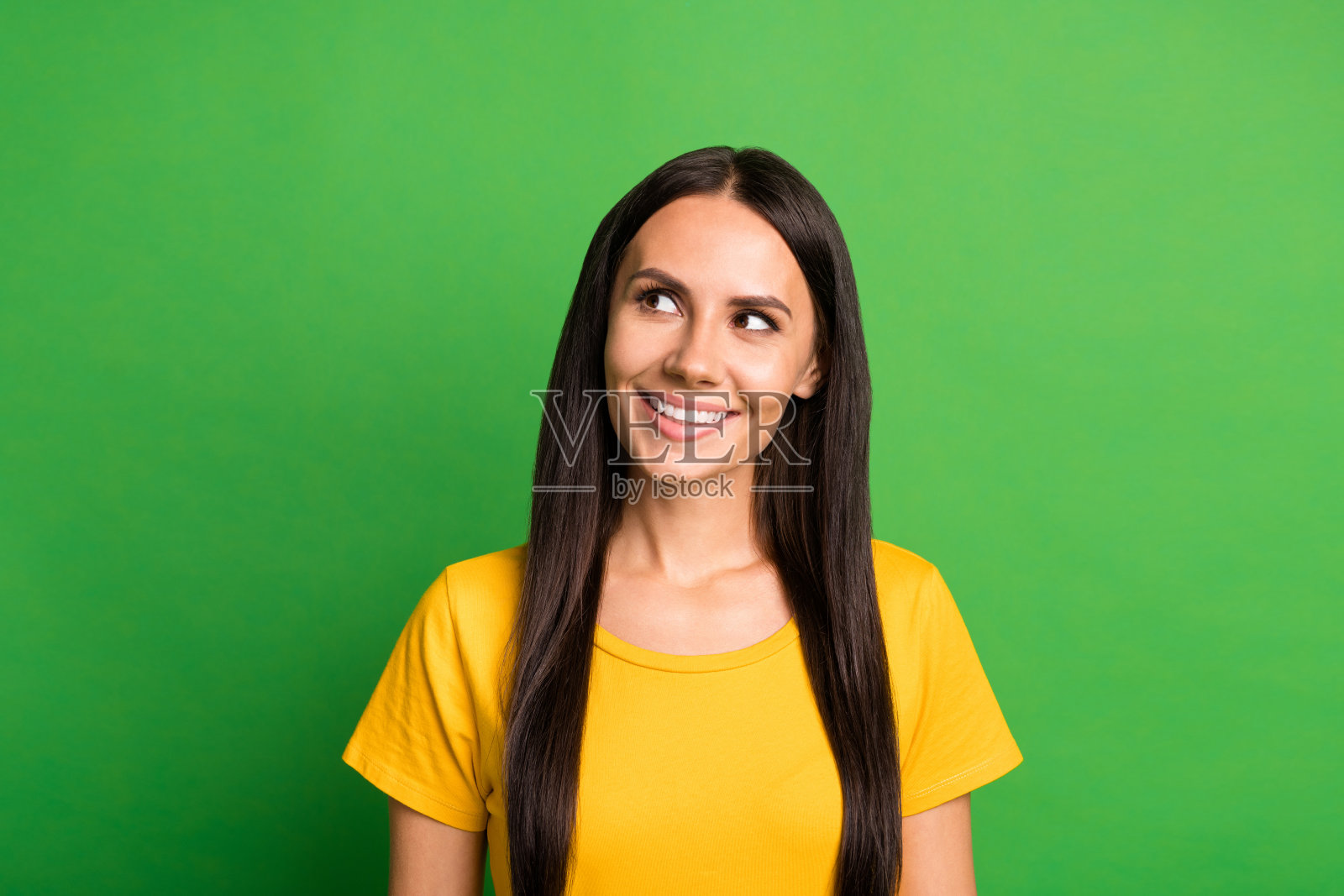 年轻迷人的女性,快乐积极,微笑,梦幻般的神情,空旷的空间,背景为绿色照片摄影图片