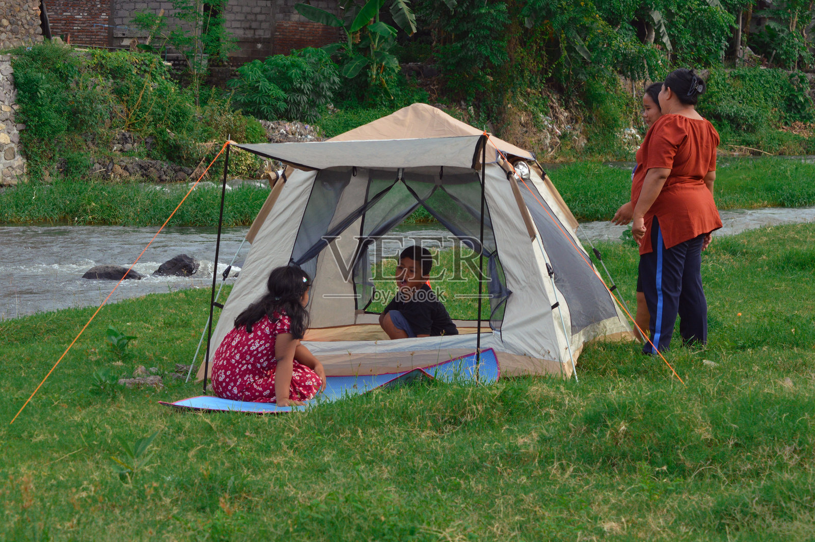 男孩在帐篷里对坐在外面的女孩说话照片摄影图片