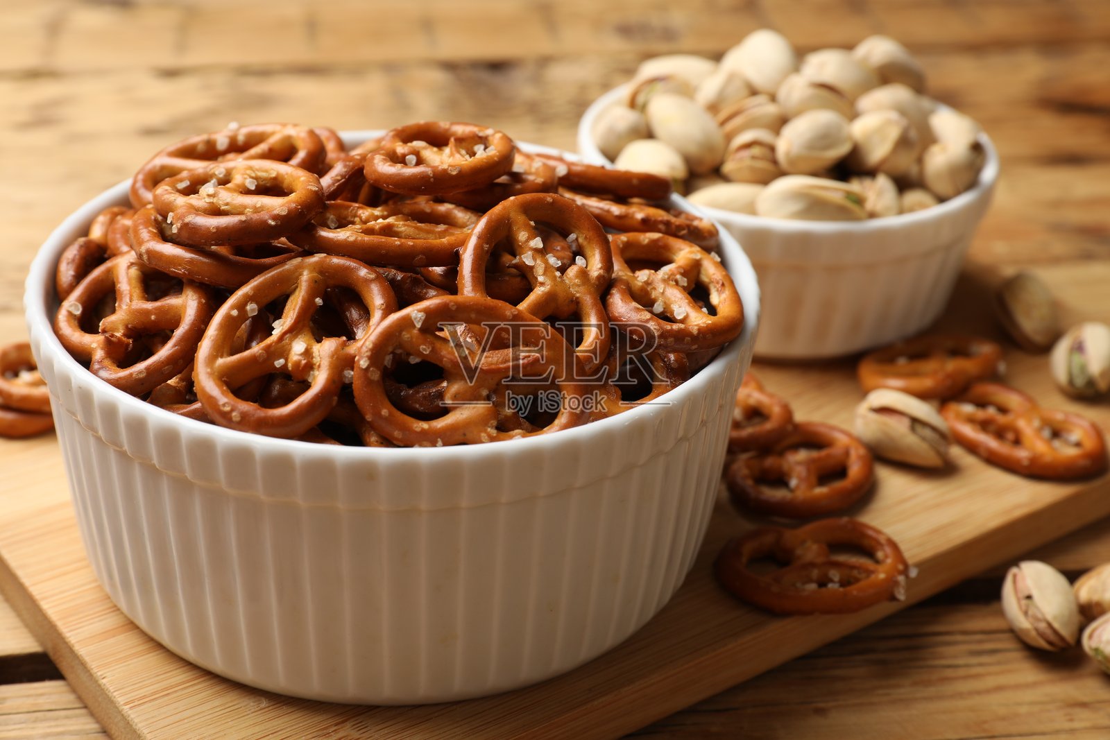 美味的椒盐饼干和开心果放在木桌上,特写镜头照片摄影图片