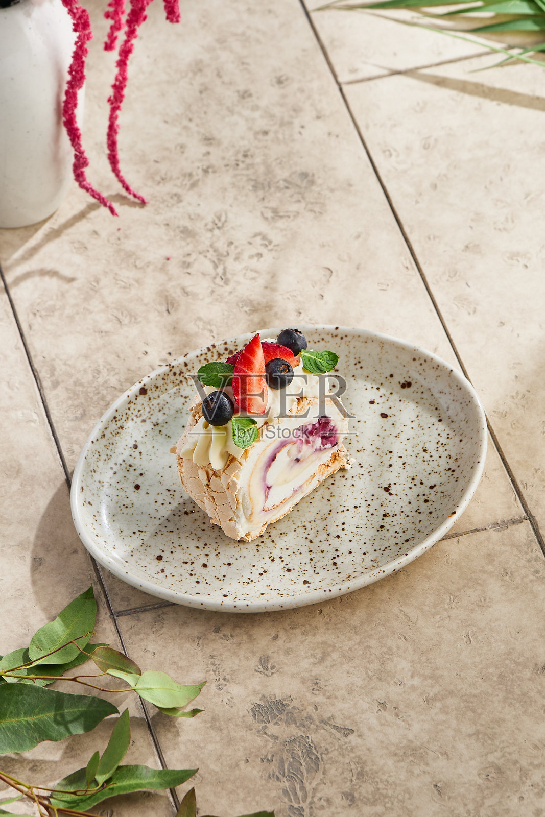 浆果顶饰的蛋白霜卷,明亮的自然光,简约的俯视构图照片摄影图片