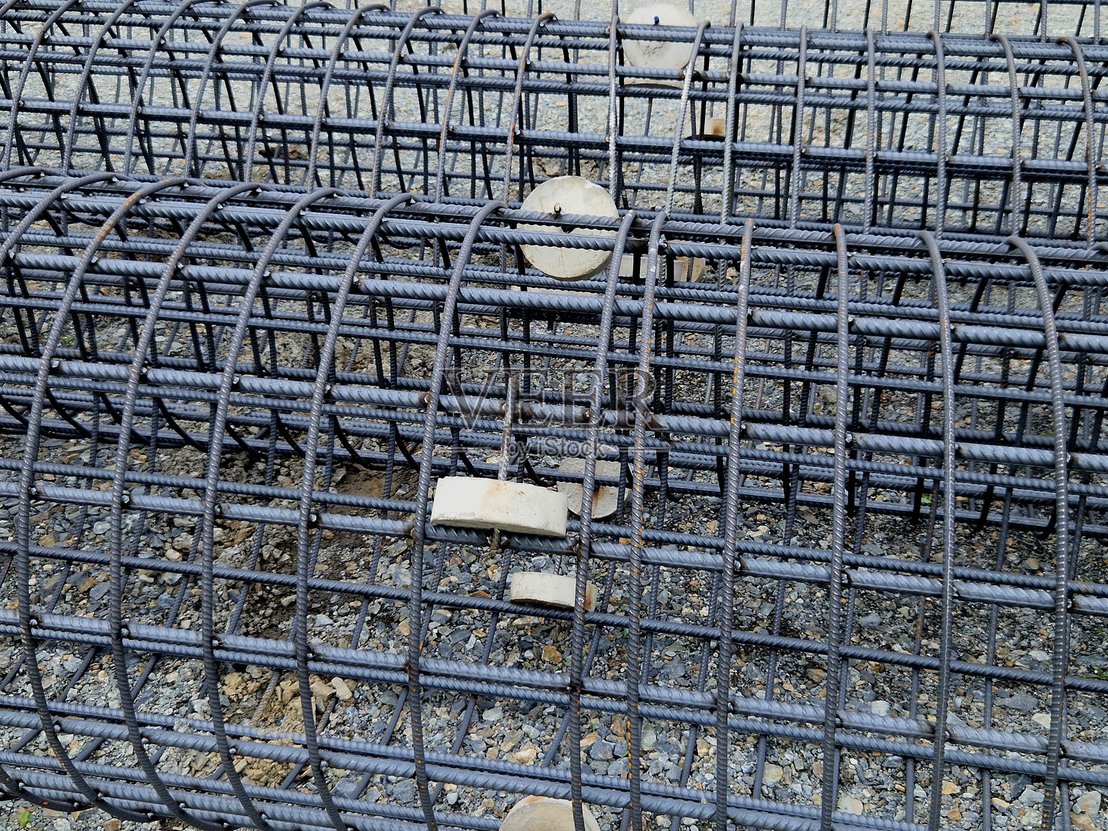 建筑基础网格中的钢筋混凝土圆柱杆结构。桩基础填充混凝土。滚轮允许地下插入,锚固。照片摄影图片