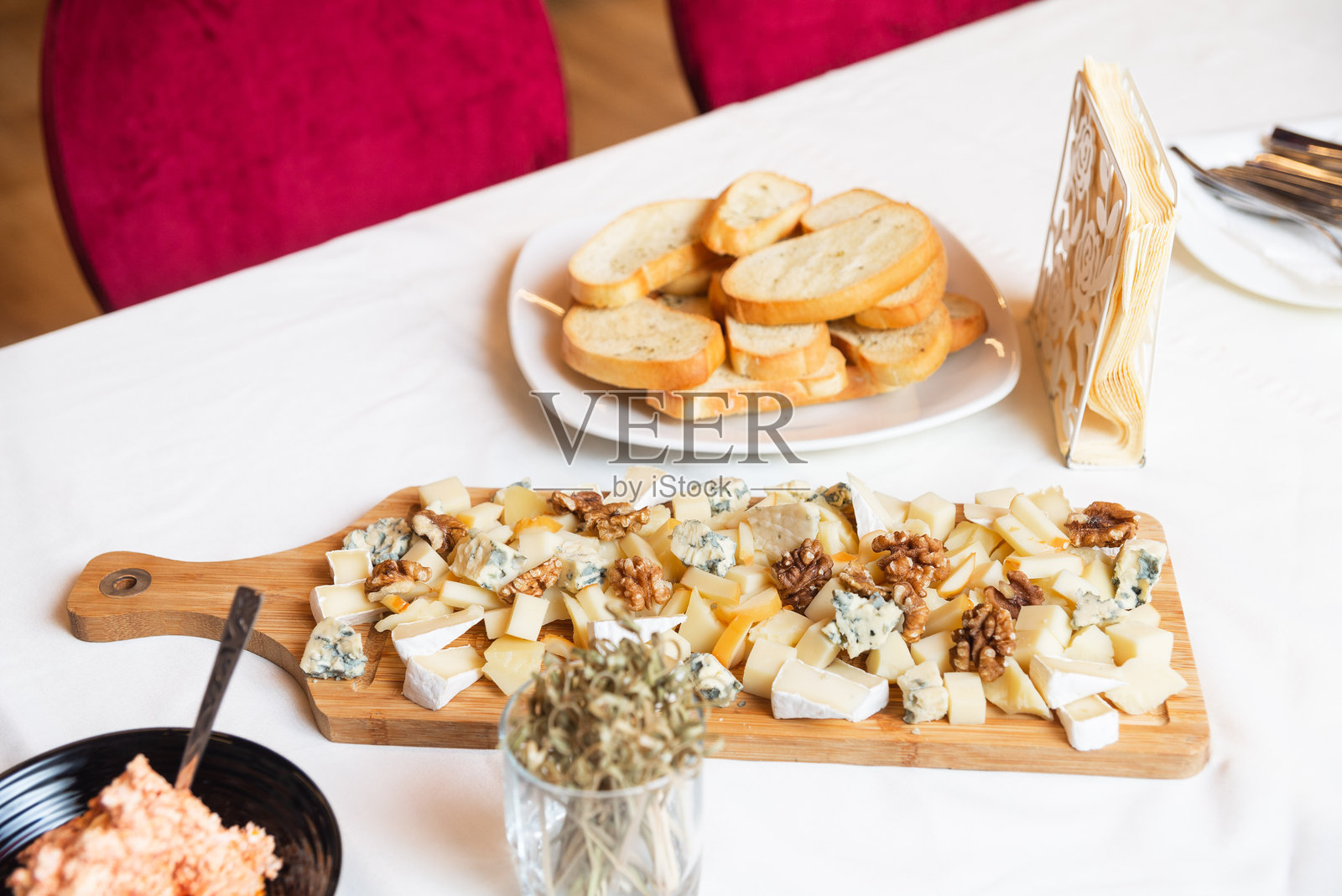 各种奶酪拼盘配核桃和面包。照片摄影图片