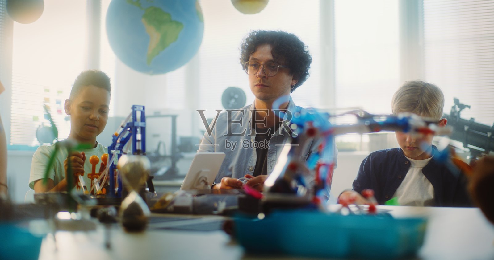 一群聪明的孩子和年轻老师在进行STEM课程的拼装活动照片摄影图片