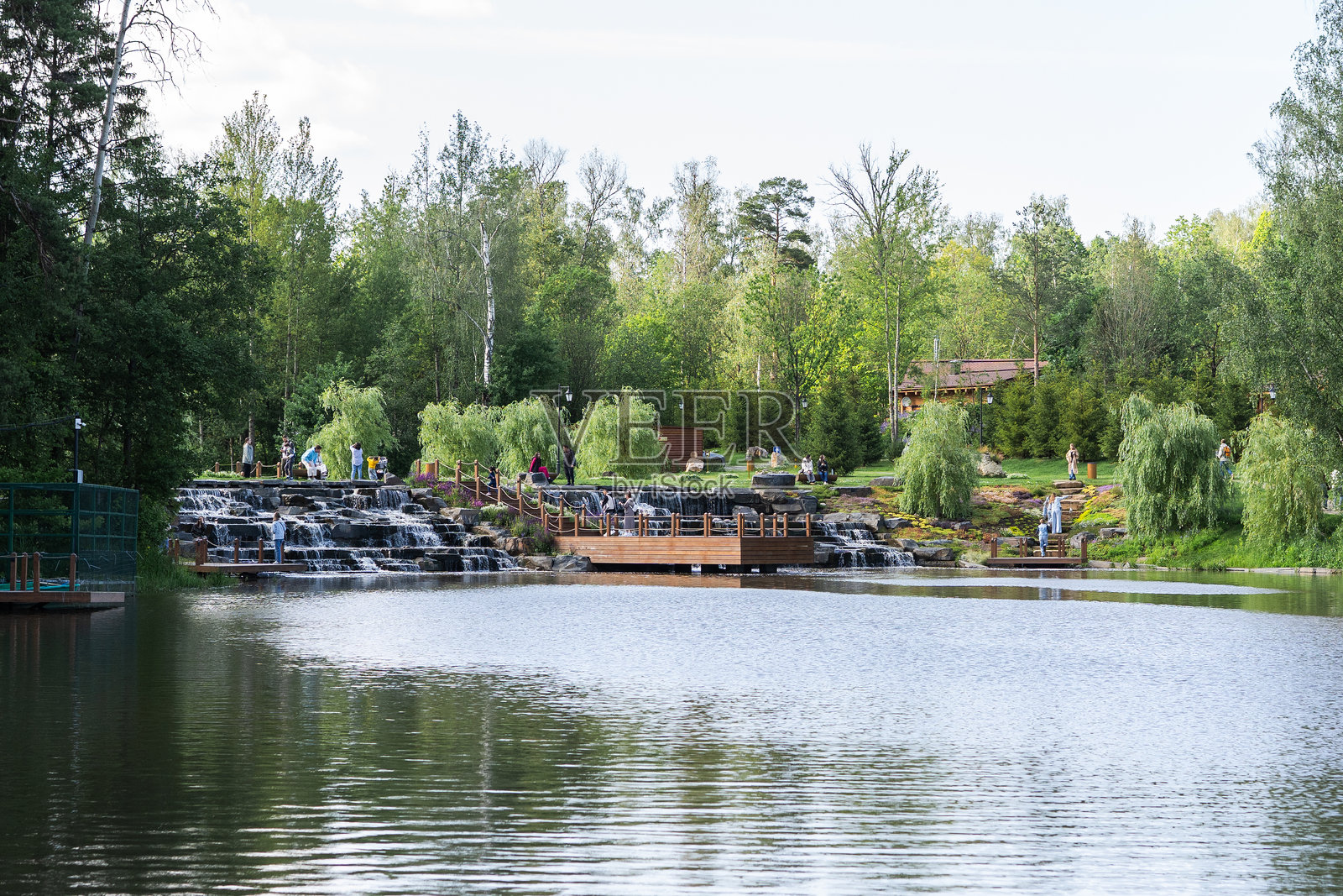 享受被郁郁葱葱的绿树和风景如画的小径环绕的宁静湖景照片摄影图片