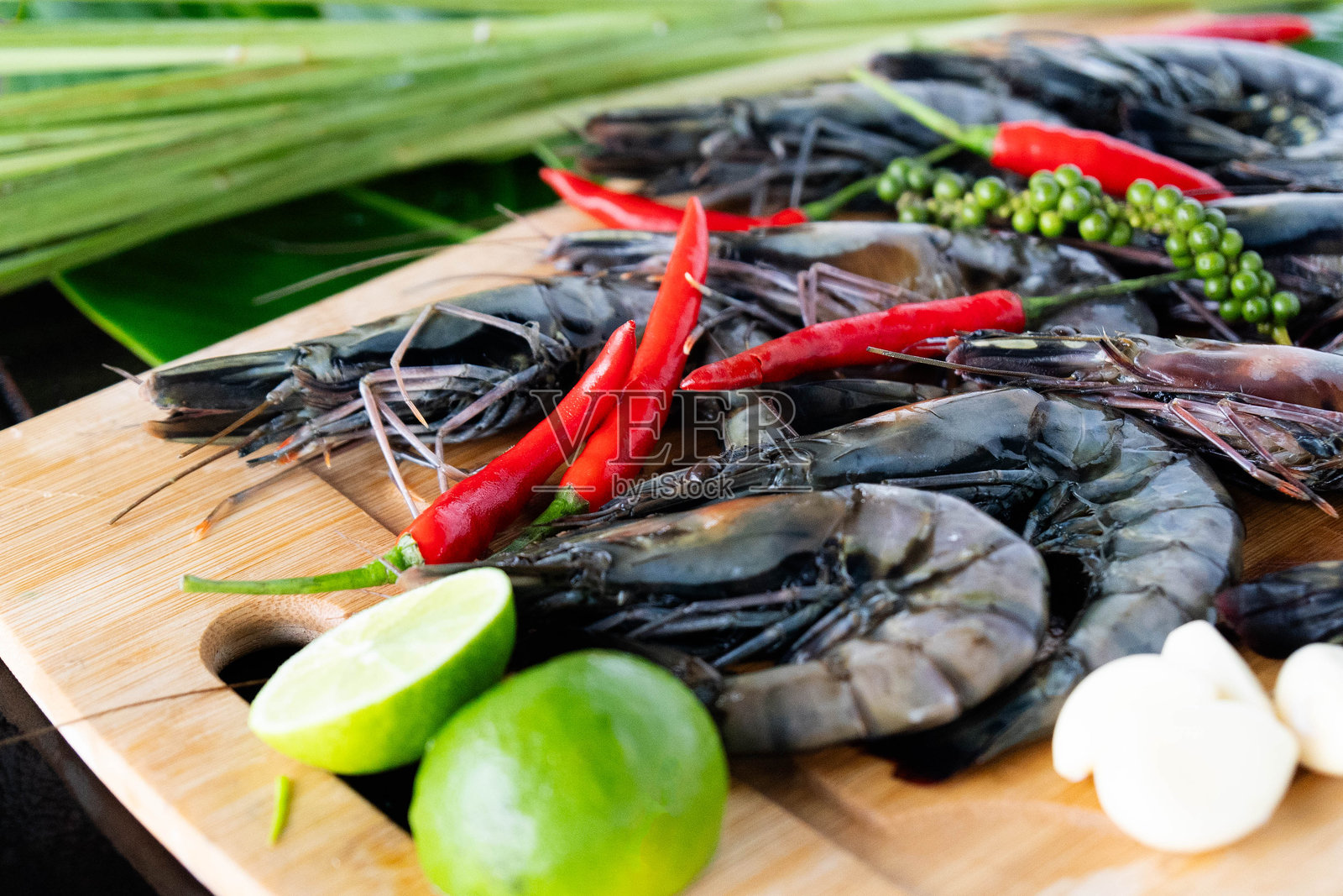 新鲜准备的老虎虾放在香蕉叶上,配以丰富的香料,呈现在传统的亚洲厨房中照片摄影图片