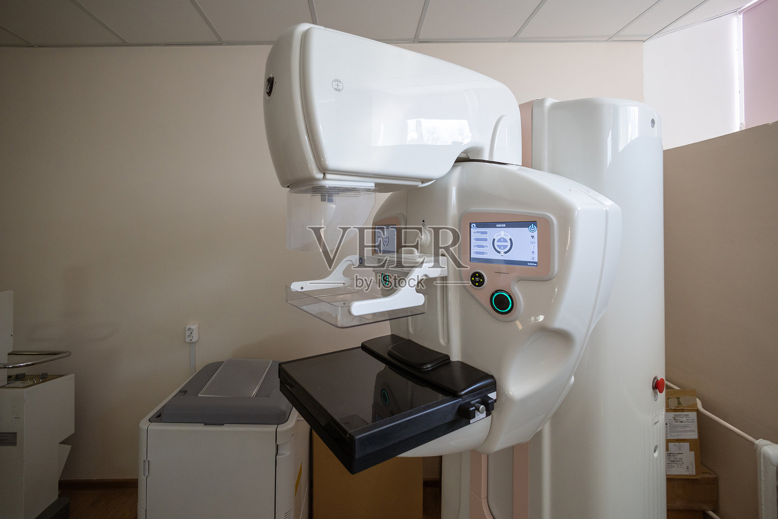 一台配有双互动屏幕的现代乳腺摄影机矗立在干净的医疗室内,随时准备进行诊断影像检查。照片摄影图片