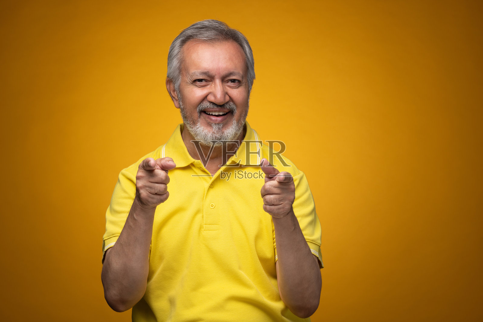 穿着黄色T恤的老年帅气男士肖像照片,背景为黄色。照片摄影图片