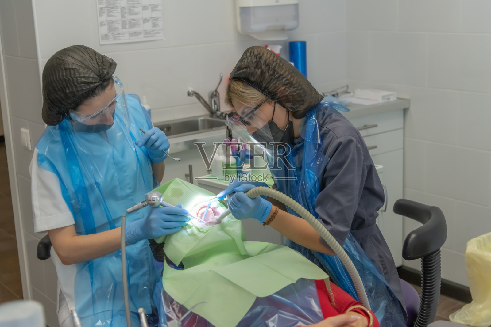 牙科专业人员在诊所内共同为患者提供护理和治疗。照片摄影图片