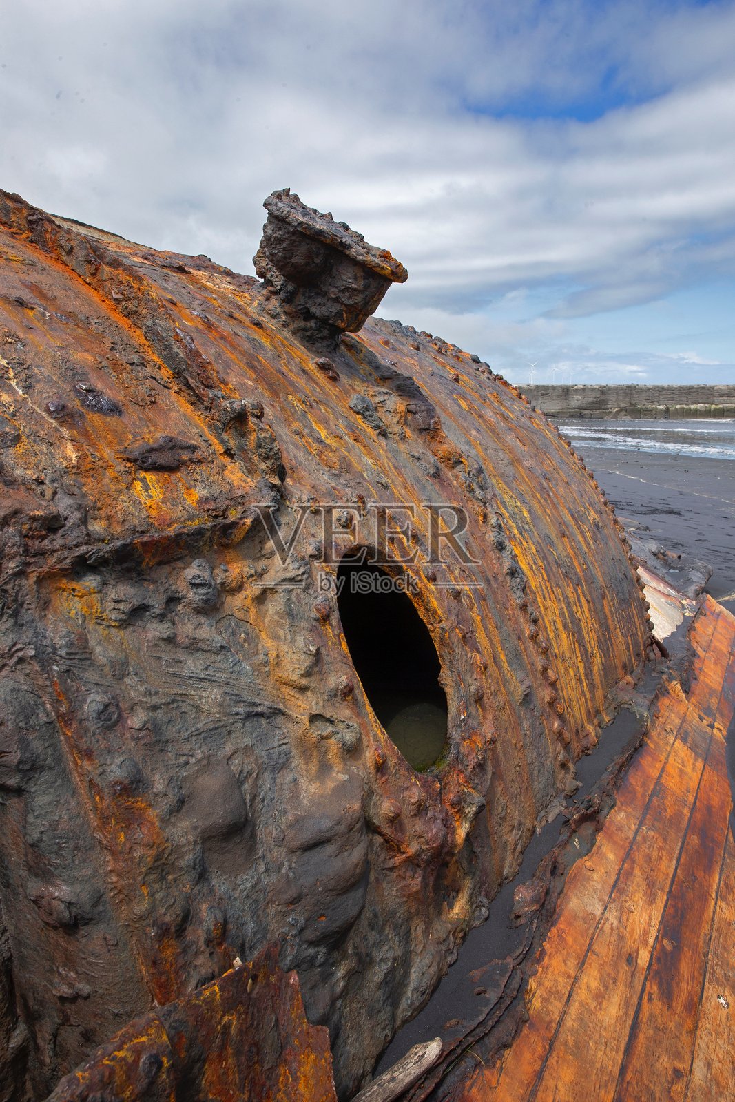 塔斯曼海的帕特亚海滩上锈蚀的金属船wreck,离塔拉纳基不远。照片摄影图片