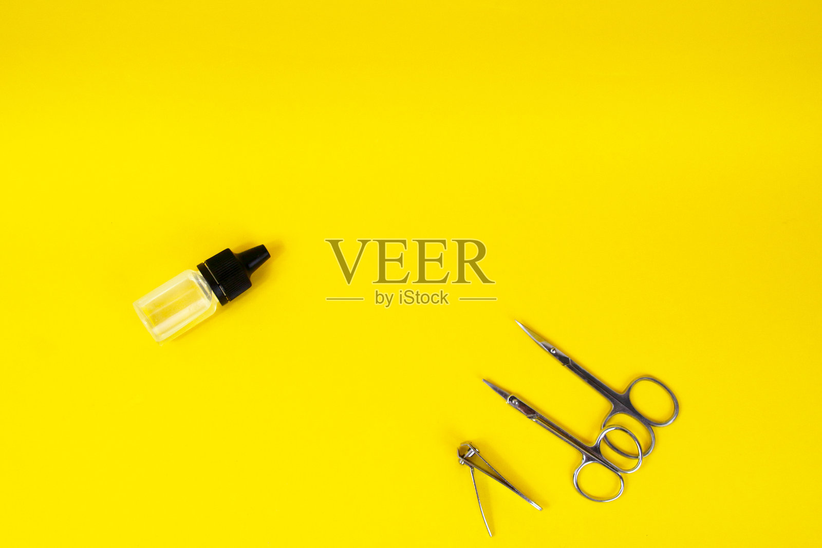 黄色背景上的金属剪刀和钳子。美甲,美足概念照片摄影图片