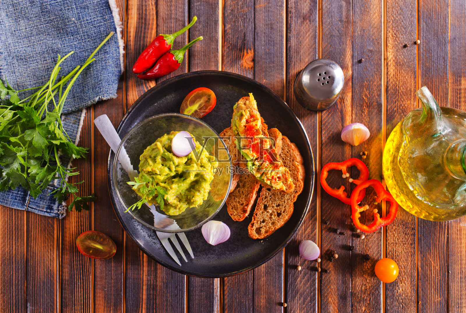 传统墨西哥蘸酱鳄梨酱放在碗里,旁边有面包烤片照片摄影图片
