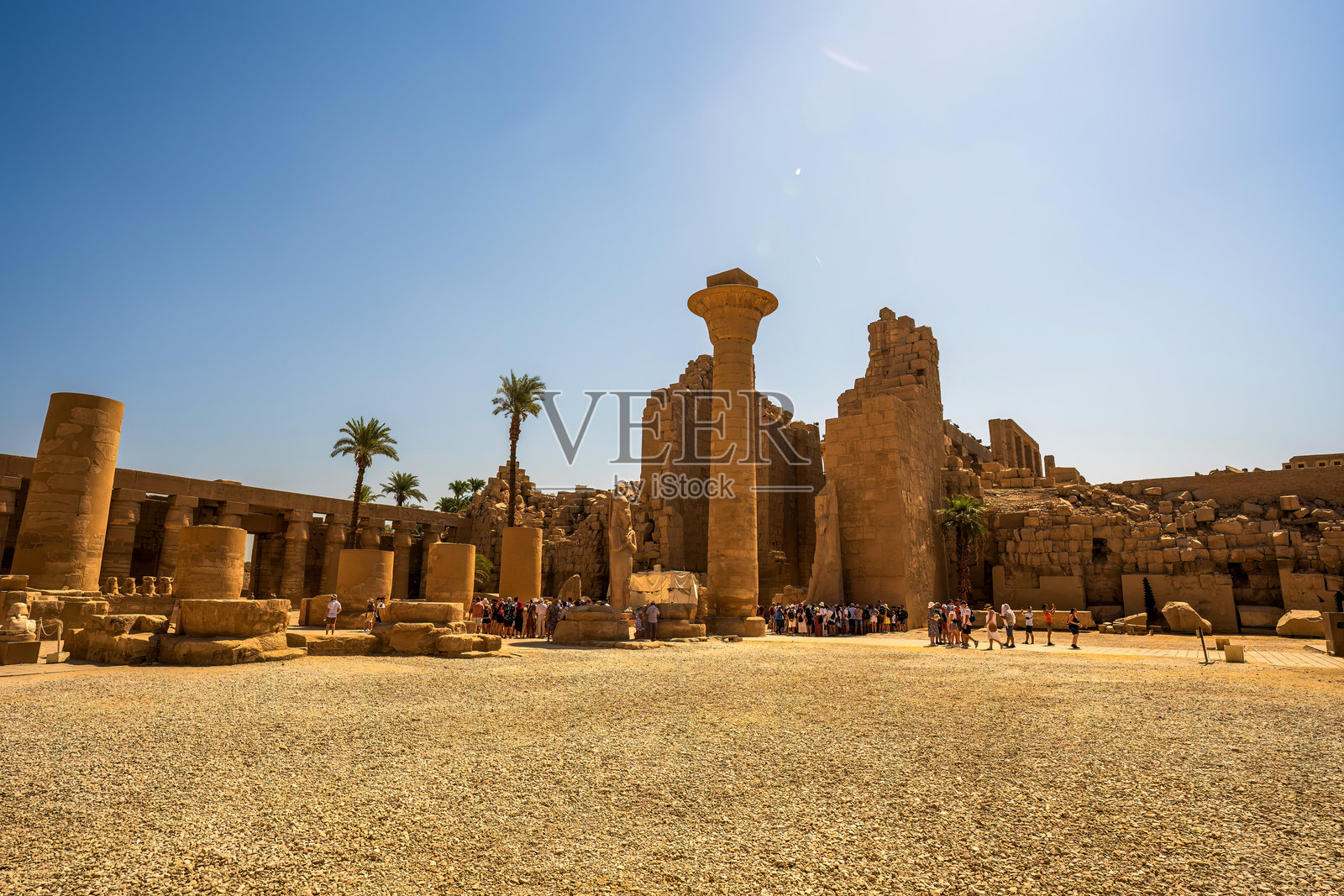 埃及卢克索的卡尔纳克神庙广阔的古代遗址,耸立的柱子和墙壁在晴朗的蓝天下。照片摄影图片