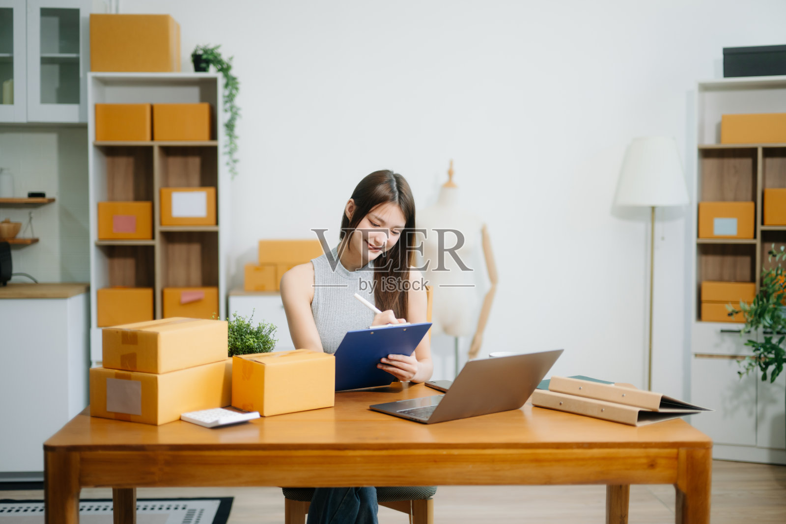 女性创业者使用智能手机或平板电脑进行小型企业的收款照片摄影图片