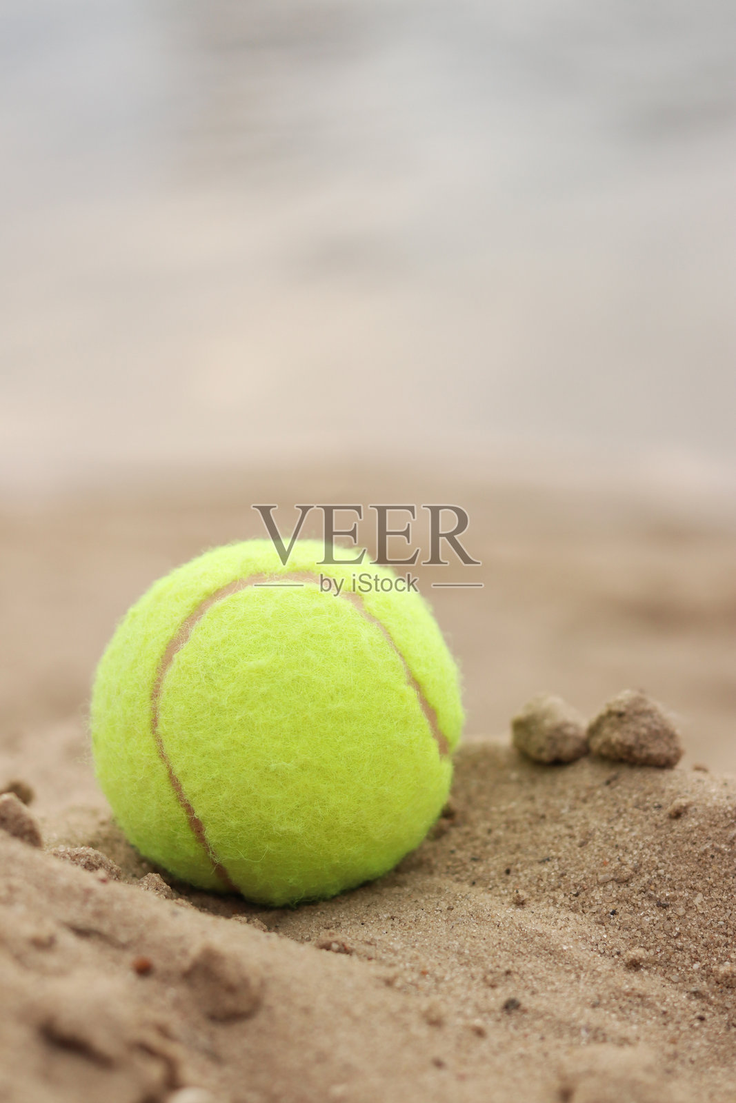 黄色网球静静地躺在沙滩上。户外游戏照片摄影图片