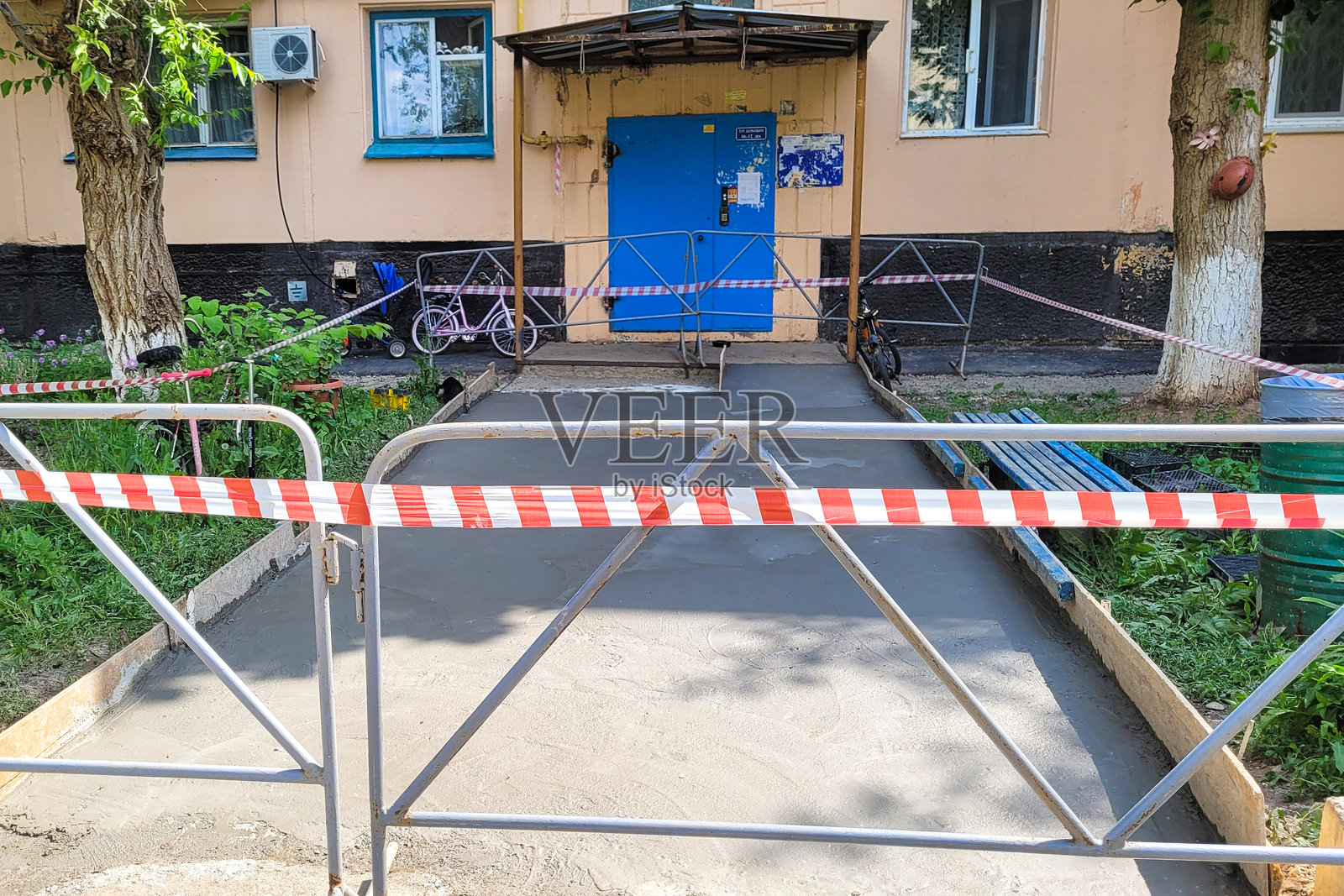 住宅建筑入口处的沥青修复,周围有警告带照片摄影图片