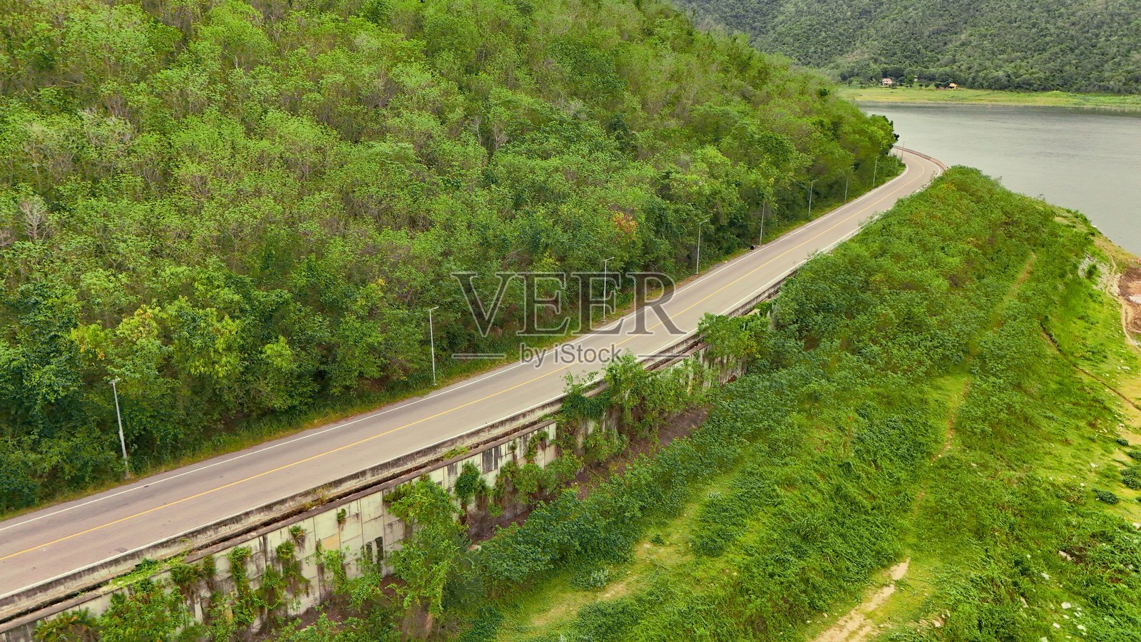 森林中间的公路鸟瞰图。通过森林的沥青公路顶视图,汽车冒险之旅。健康环境的公路旅行。照片摄影图片