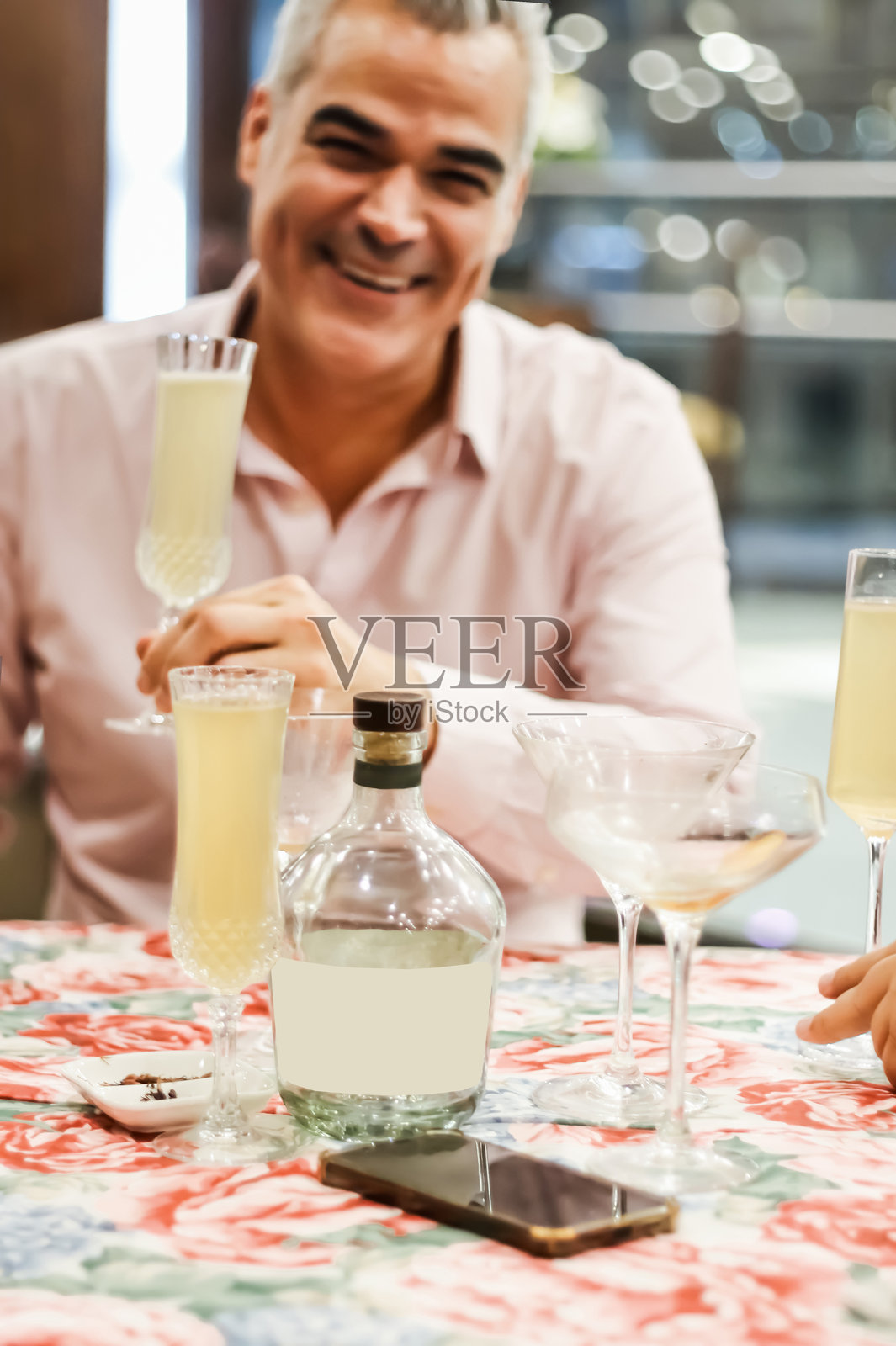 微笑的成熟男性在家聚会上享受饮品照片摄影图片