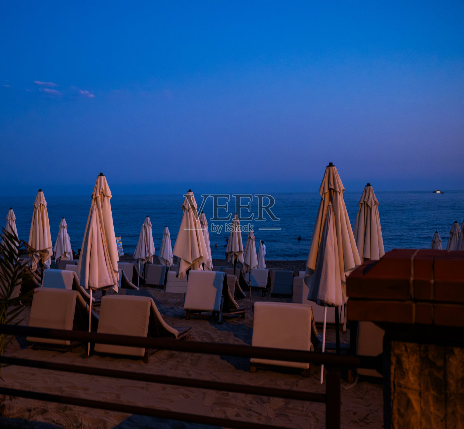 黄昏时分海滩上的闭合遮阳伞照片摄影图片