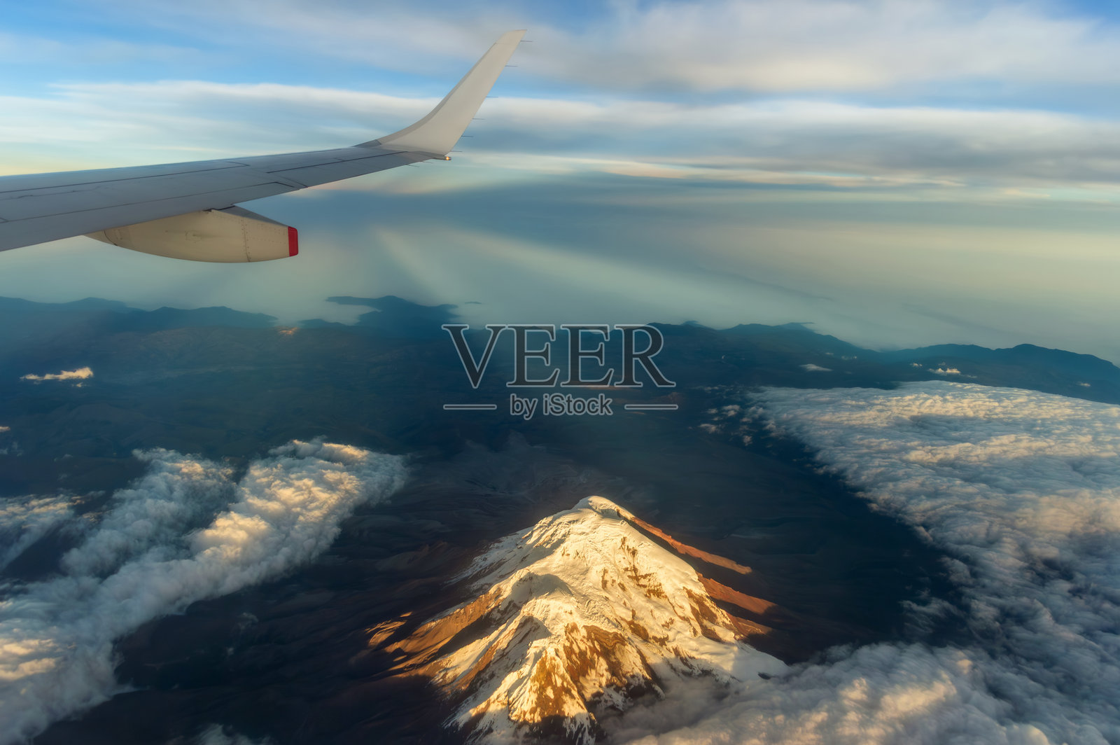 从商业飞机窗户看到的奇姆博拉索山日出。照片摄影图片