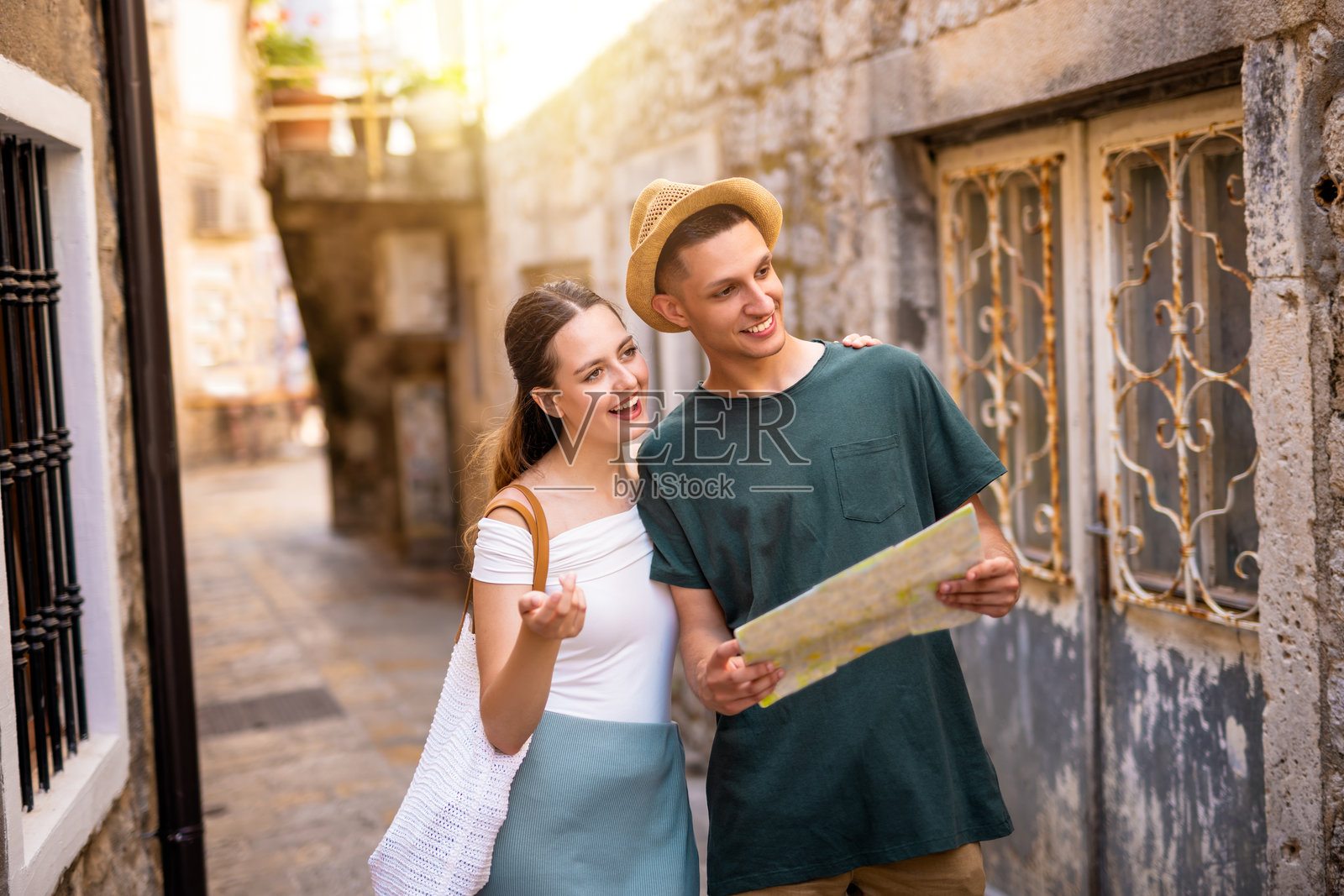 情侣在夏日的海边古镇探索,手持地图。照片摄影图片