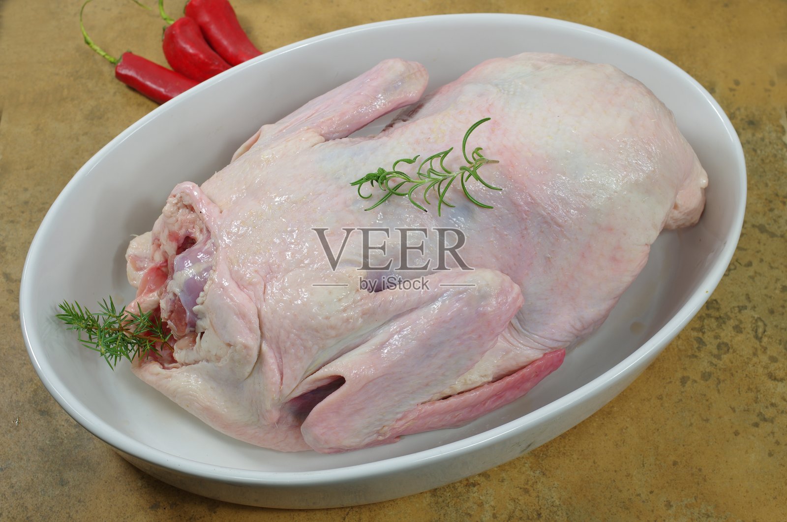 盘子里的生鸭肉与杜松子照片摄影图片