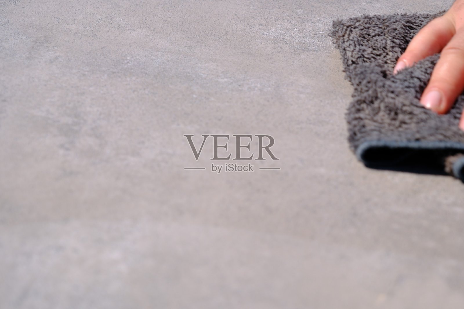 一名清洁工用手中的布擦拭地板和桌子。照片摄影图片