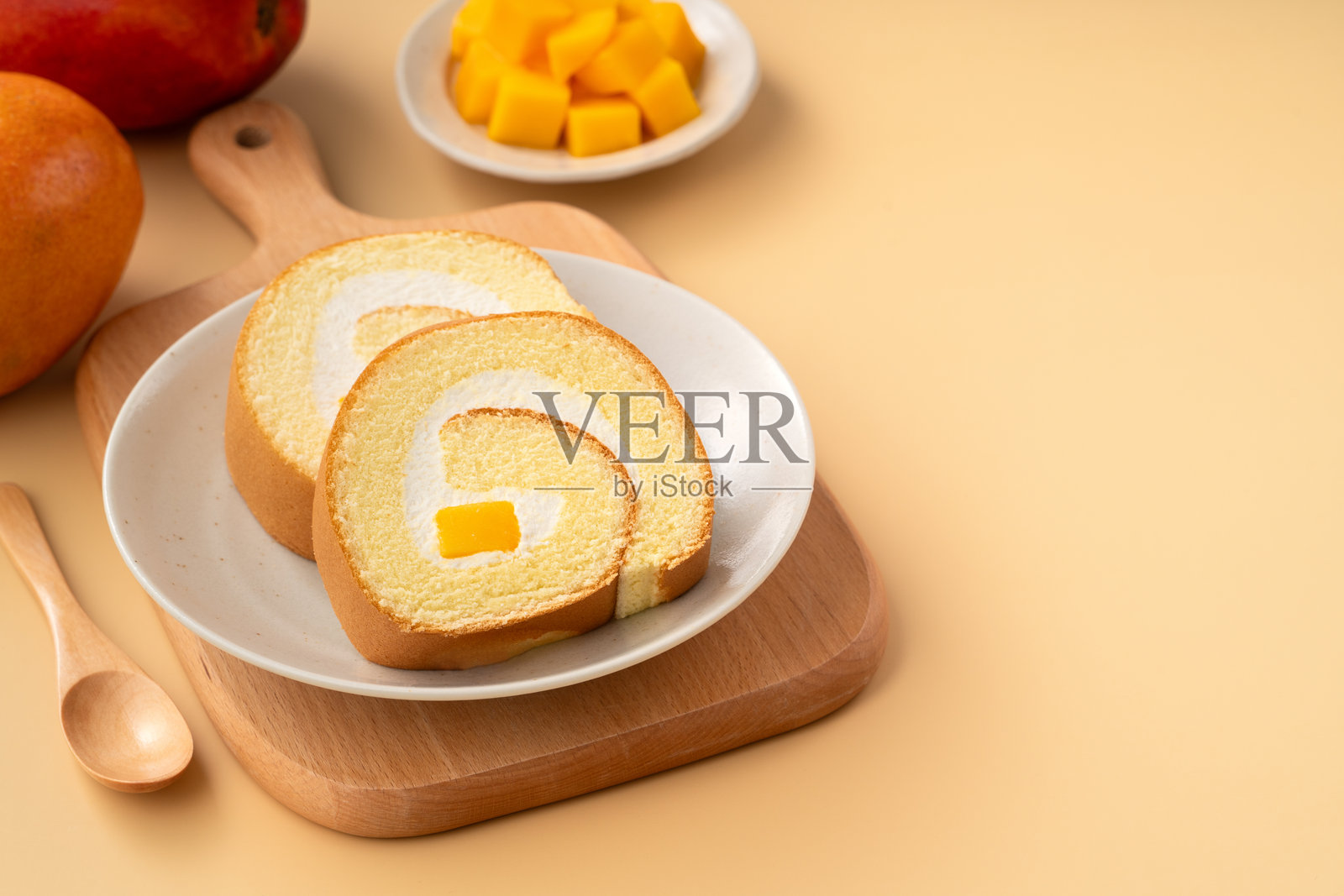 美味的芒果奶油瑞士卷蛋糕放在盘子上照片摄影图片