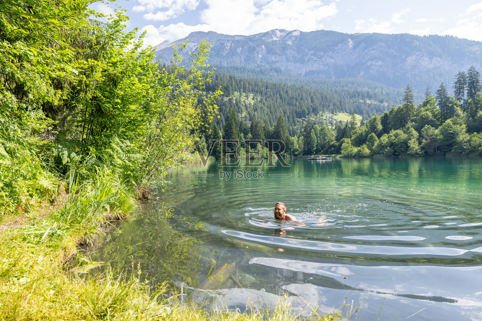 在宁静的山湖中游泳的男人照片摄影图片