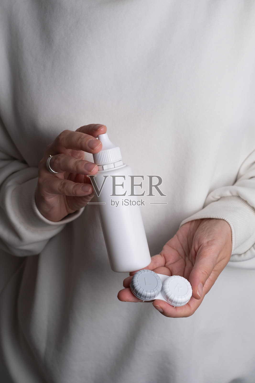 视力问题,特写镜头下的女性手持隐形眼镜盒。隐形眼镜护理。眼部护理与视力概念。照片摄影图片