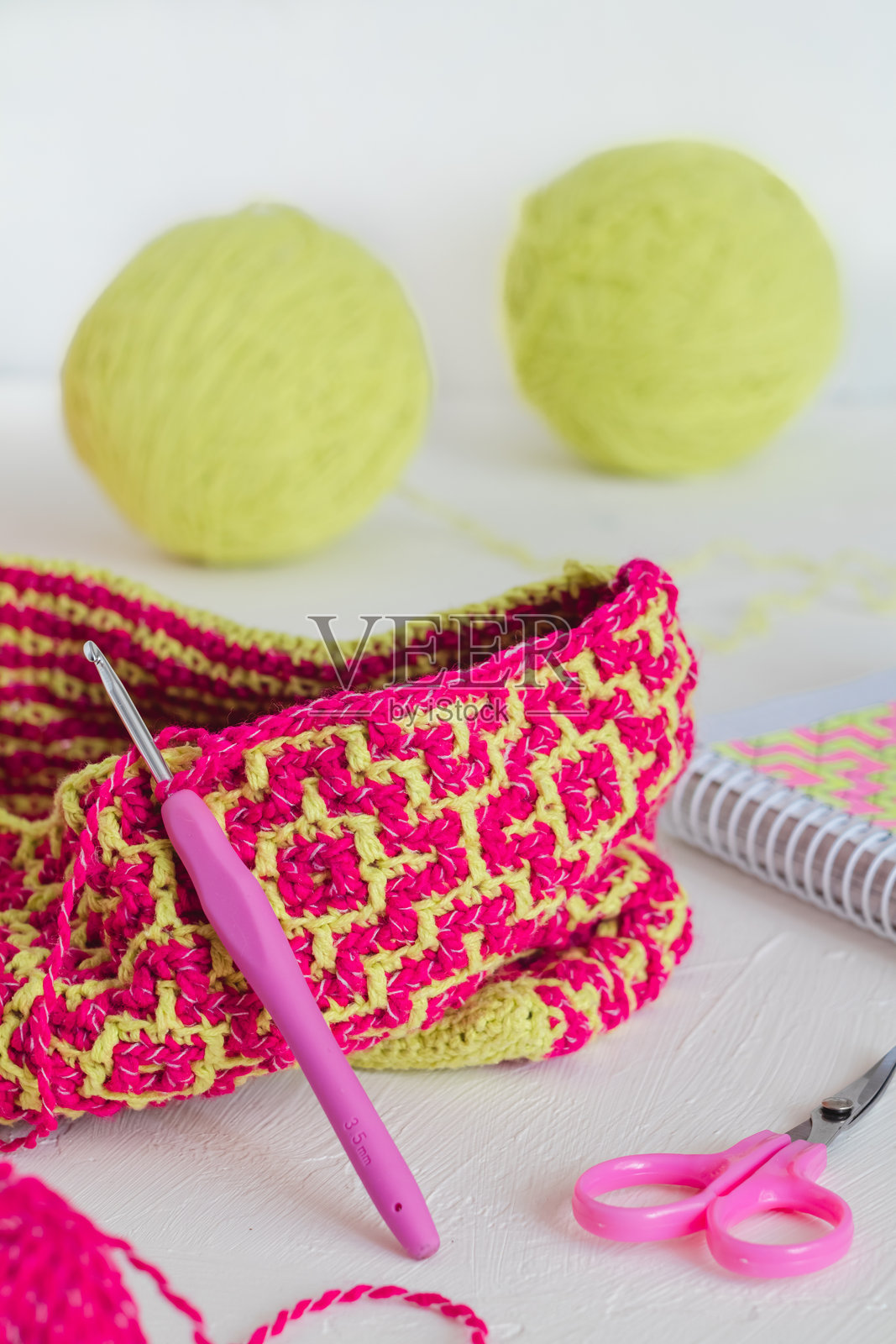 制作一个带有明亮民族几何图案的手提袋的过程。粉色和黄色的钩编纹理。手工制作的概念。照片摄影图片