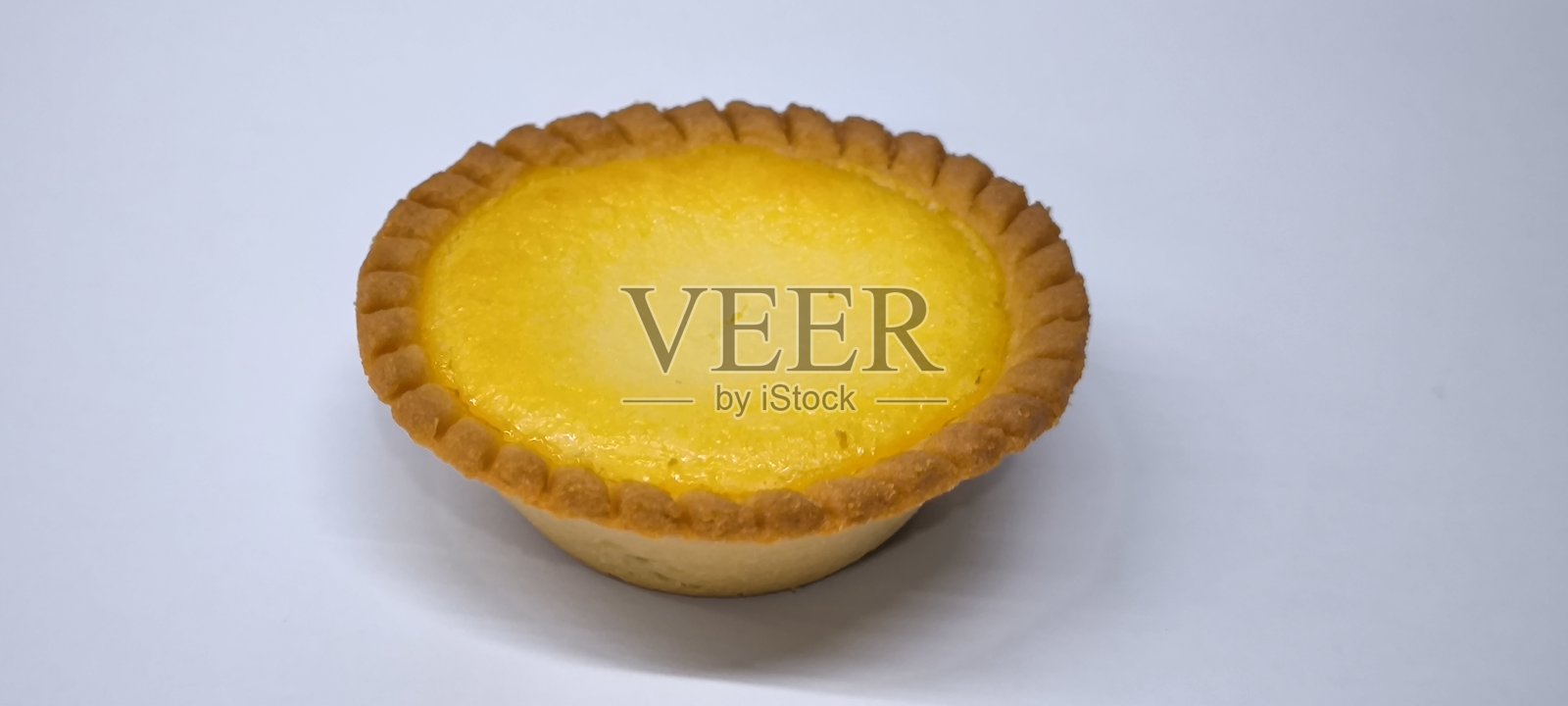 外脆内软的蛋挞,散发着浓郁奶香的蛋香味。白色背景上的蛋挞。照片摄影图片