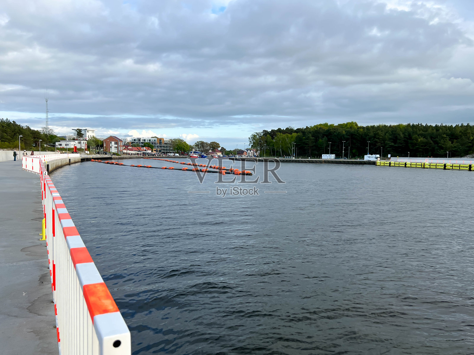 一根漂浮的管道将水从运动频道排放到外部。位于波兰Mrzeuna的海滩附近的波罗的海沿岸。照片摄影图片