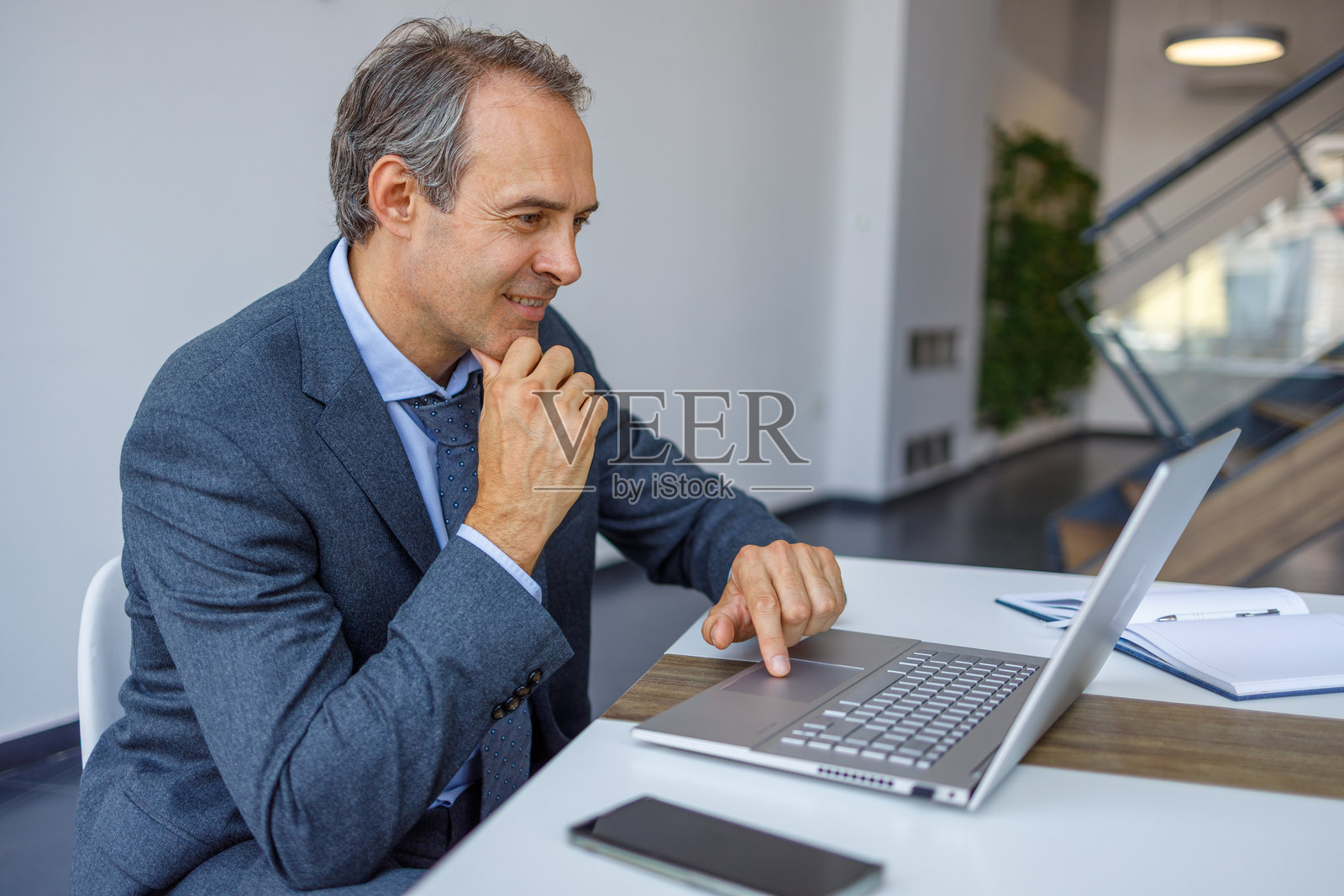 在现代办公室里工作的商人使用笔记本电脑照片摄影图片