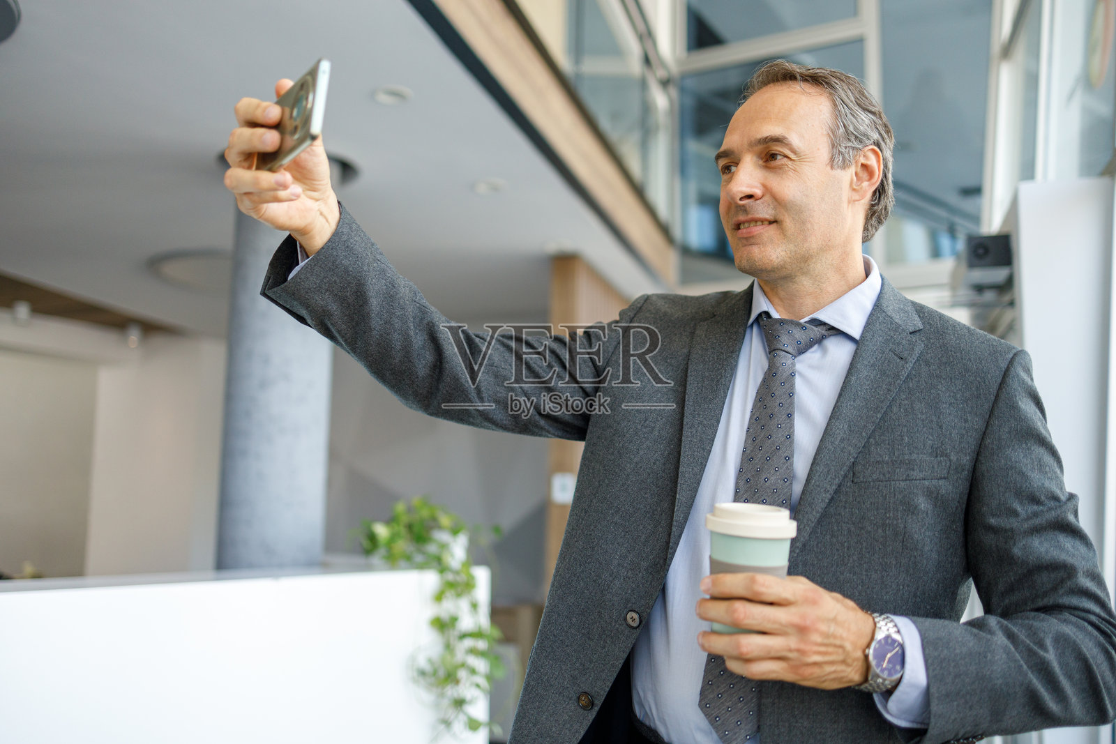 商人在办公室里喝着咖啡自拍照片摄影图片