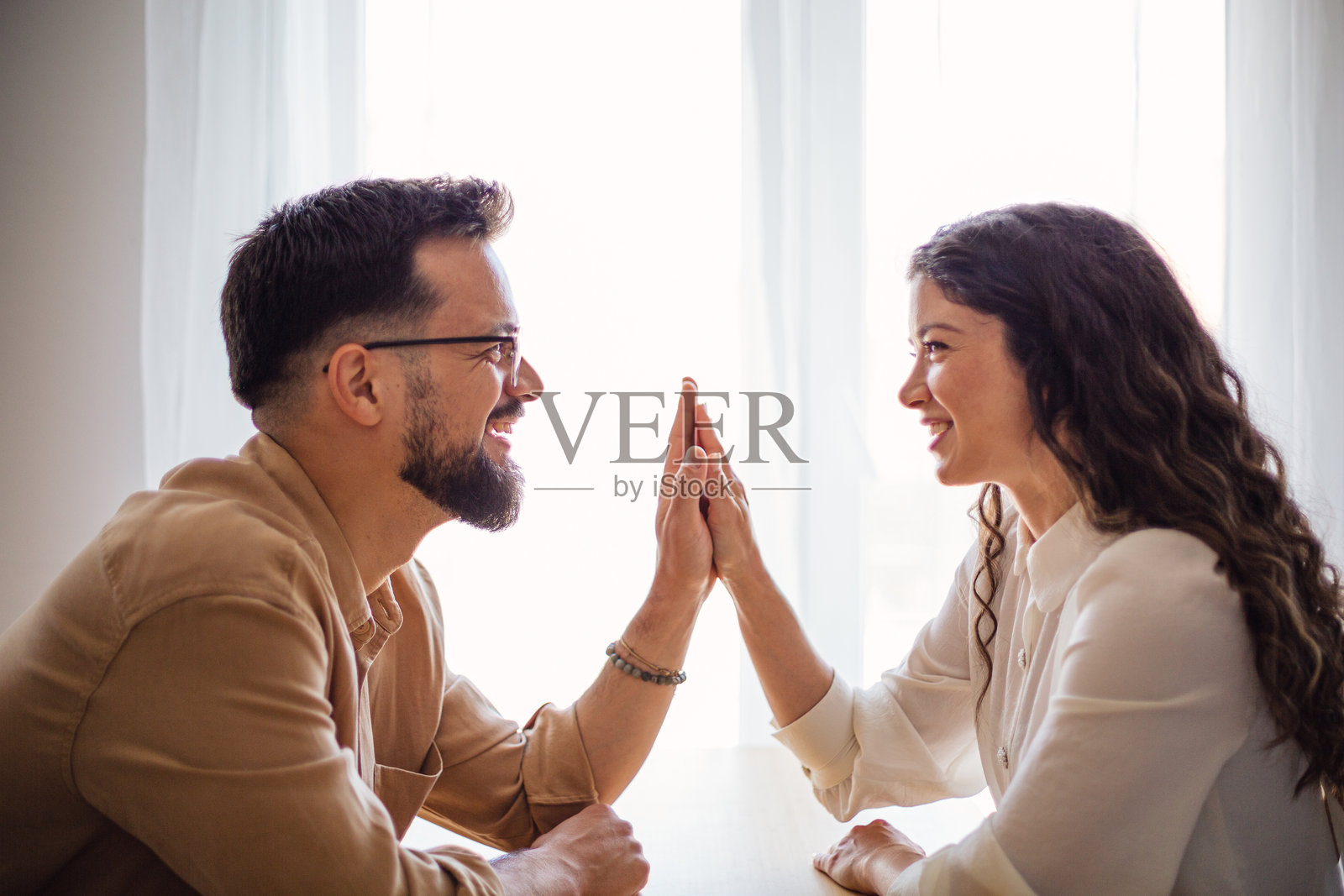 年轻情侣手牵手,在家庆祝成功照片摄影图片