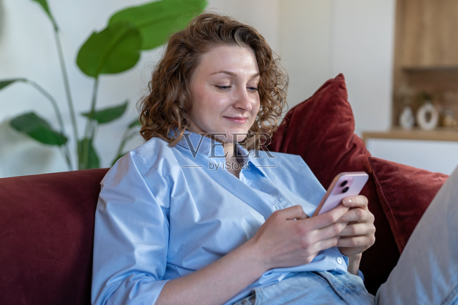 快乐的女性在休息时使用手机进行在线互动,享受浏览社交媒体和发信息的乐趣。照片摄影图片