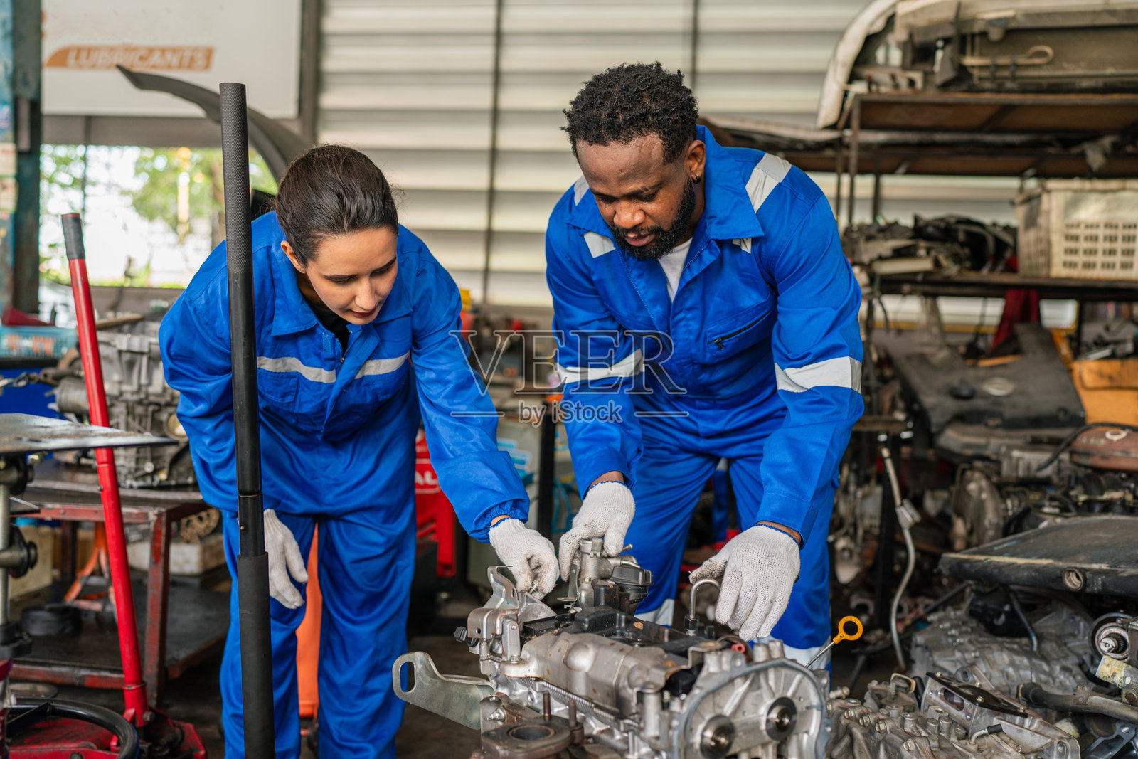 汽车维修团队正在检查和修理汽车发动机的维护工作。照片摄影图片